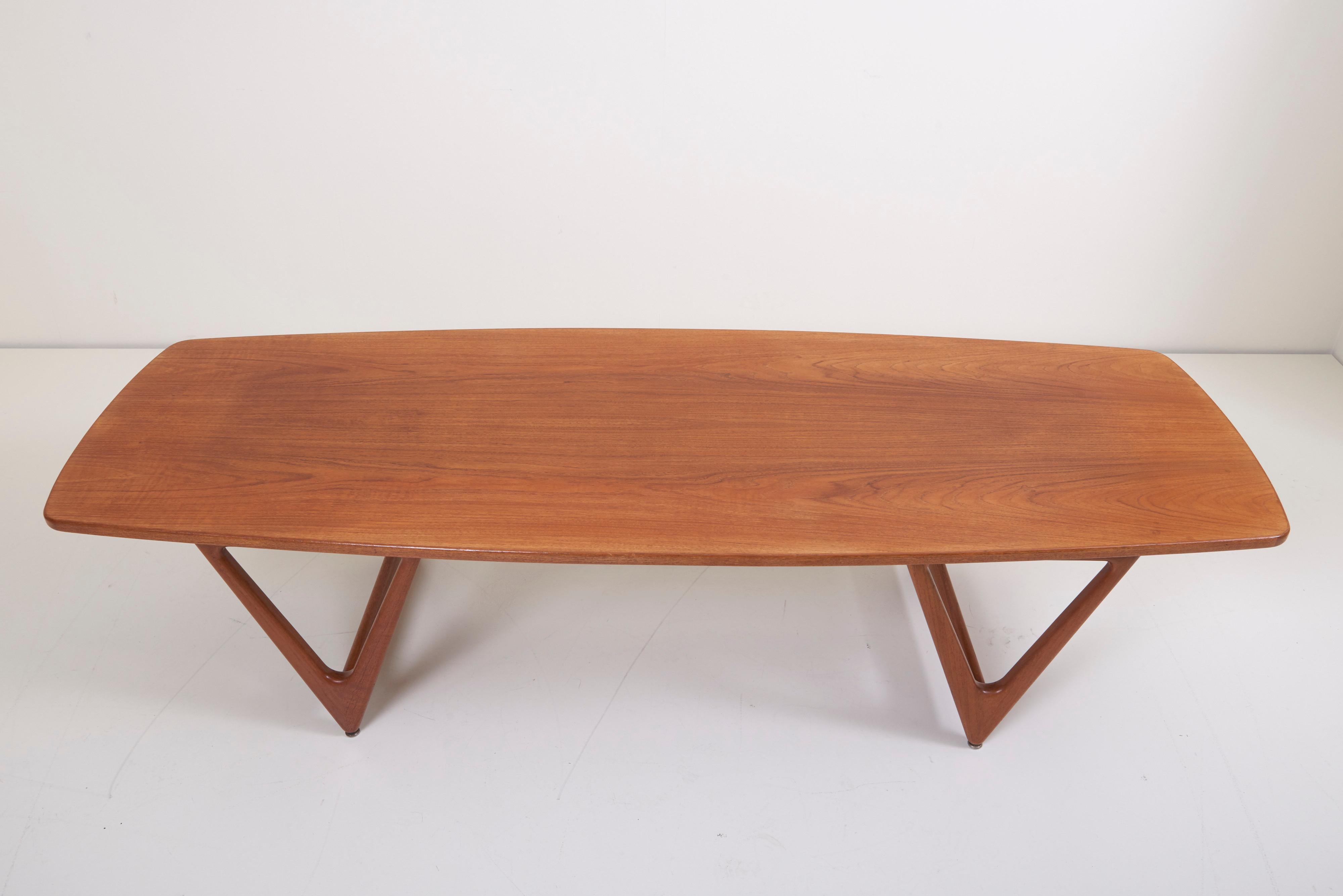 Amazing “Surfboard” coffee table by Kurt Østervig, with a long tabletop with sweeping teak veneer and cool, beautifully sculpted V-shaped legs. A real conversations piece.
