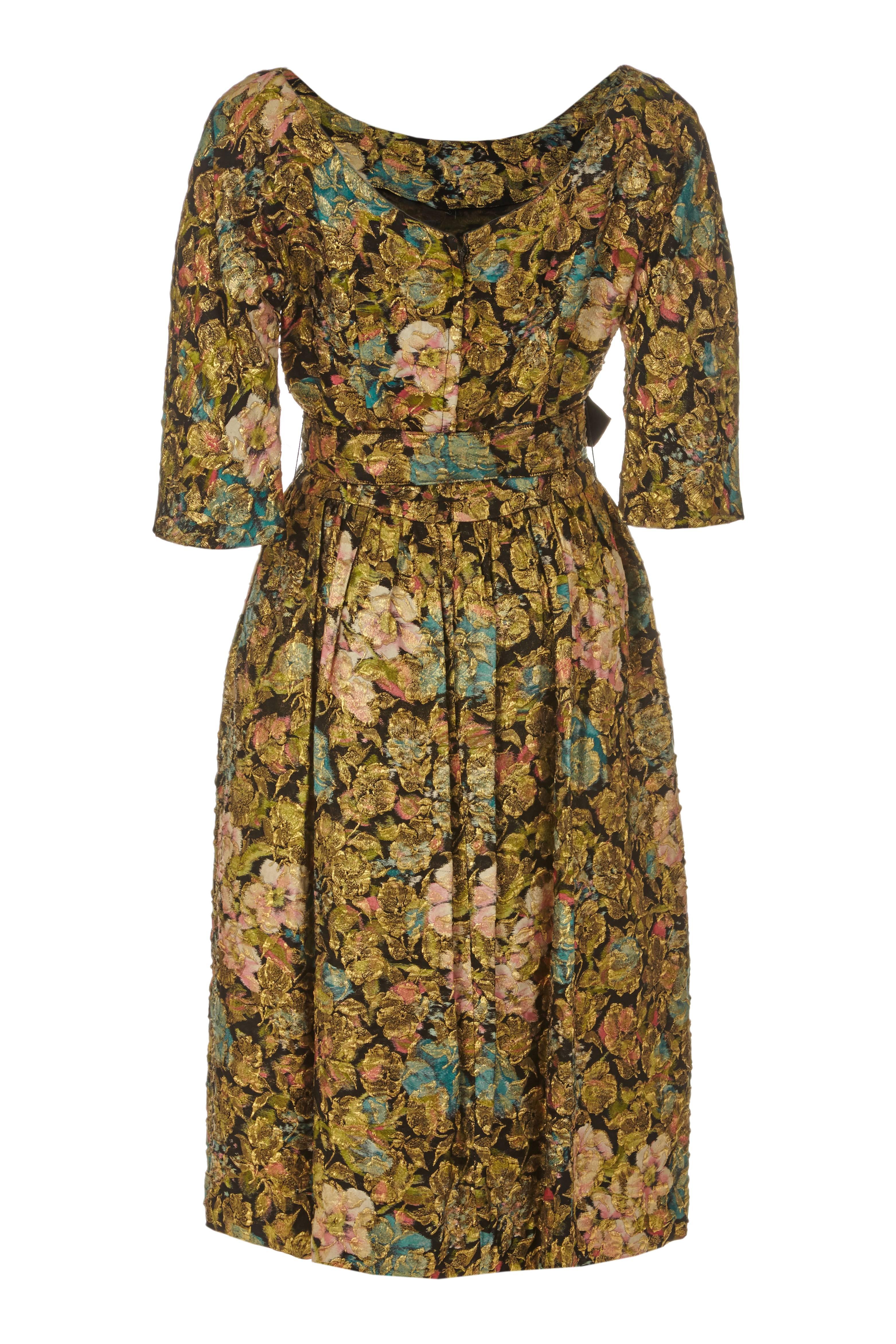 Amazing 1950s vintage dress from American label Suzy Perrette with black, blue and pink floral print and textured gold lame pattern woven throughout the silk giving a very luxurious feel. This piece features 3/4 sleeves, low scoop back and original