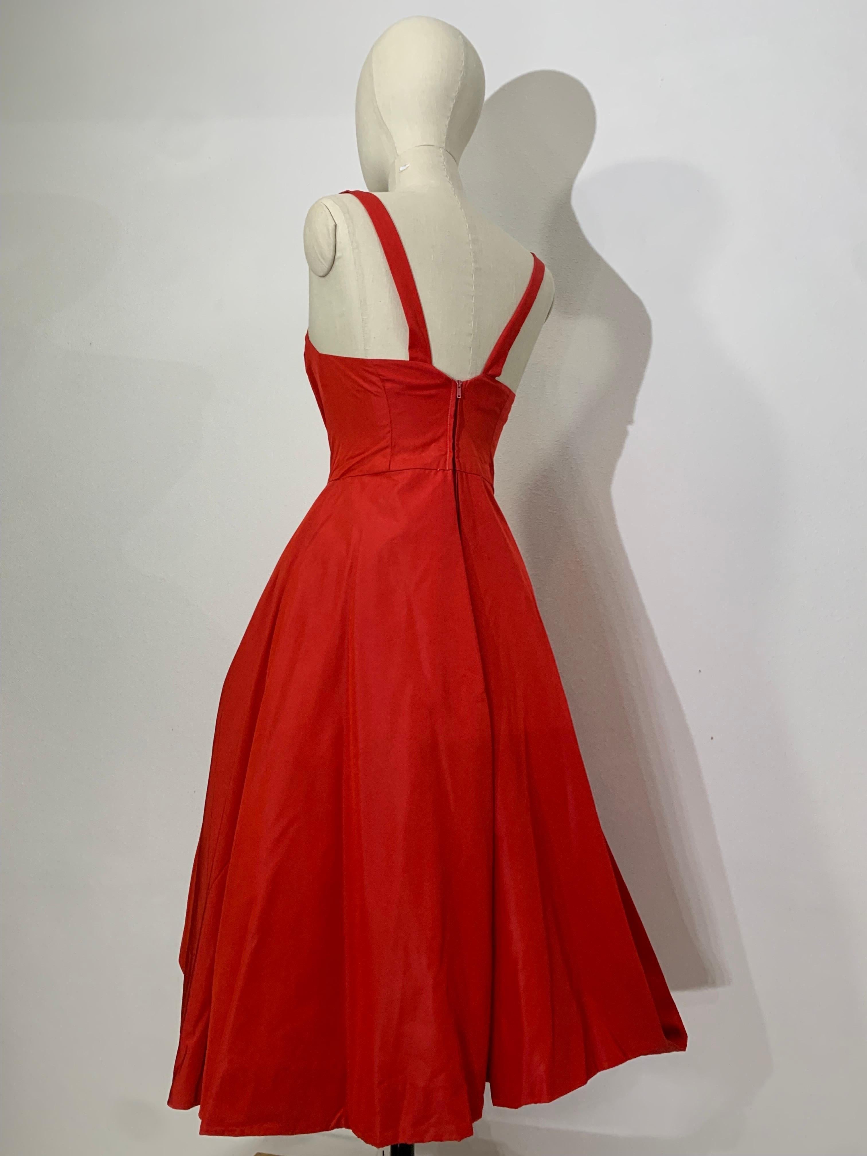 Robe de cocktail en soie rouge Suzy Perette des années 1950 avec jupe ample et drapé artistique : Cette superbe robe emblématique des années 50 a un décolleté chic en forme de tablier avec un corsage désossé et des crinolines pour un maximum de