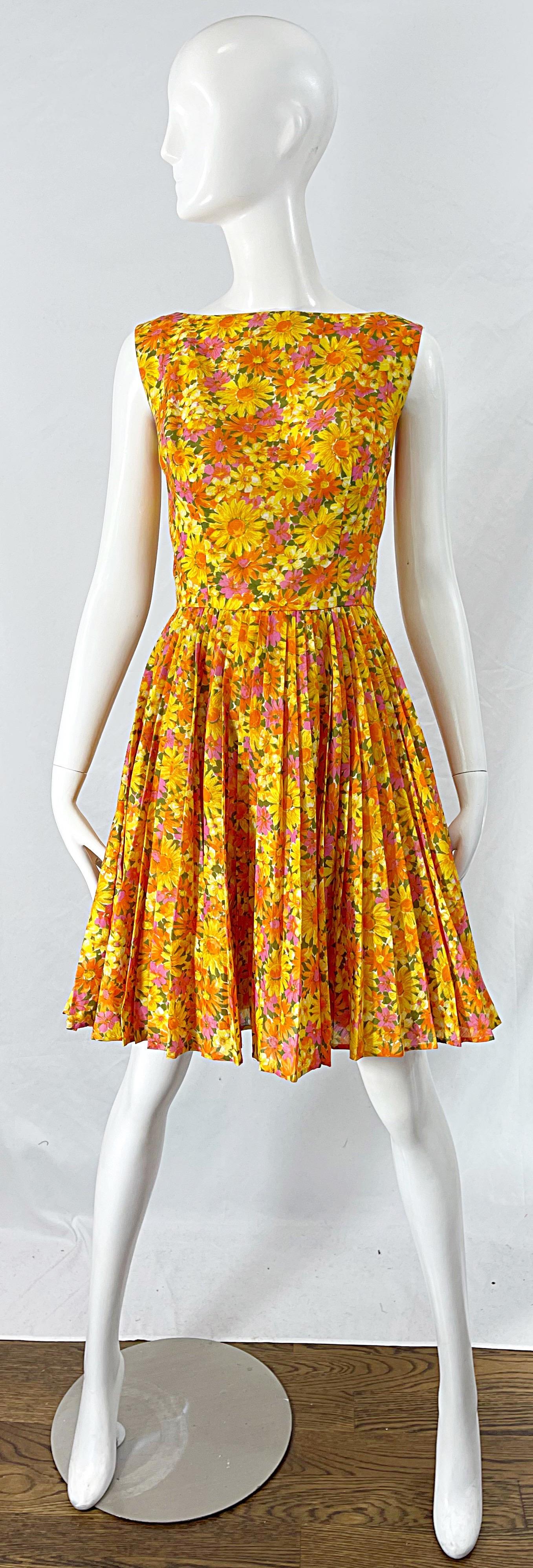 Chic 1950s SUZY PERETTE yellow, orange, pink and green daisy flower print cotton fit n’ flare dress ! Features an elegant high neck with a tailored bodice and forgiving full pleated skirt. Full metal zipper up the back with hook-and-eye closure.