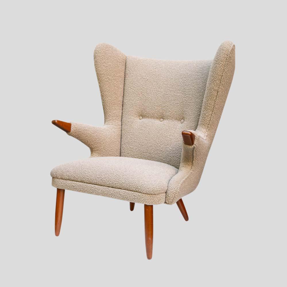Svend Skipper's wing armchair design features boucle fabric upholstery and teak wood arm endings and feet, capturing the essence of mid-century Scandinavian design. 
Fully restored, this chair offers exceptional comfort and excellent head support.