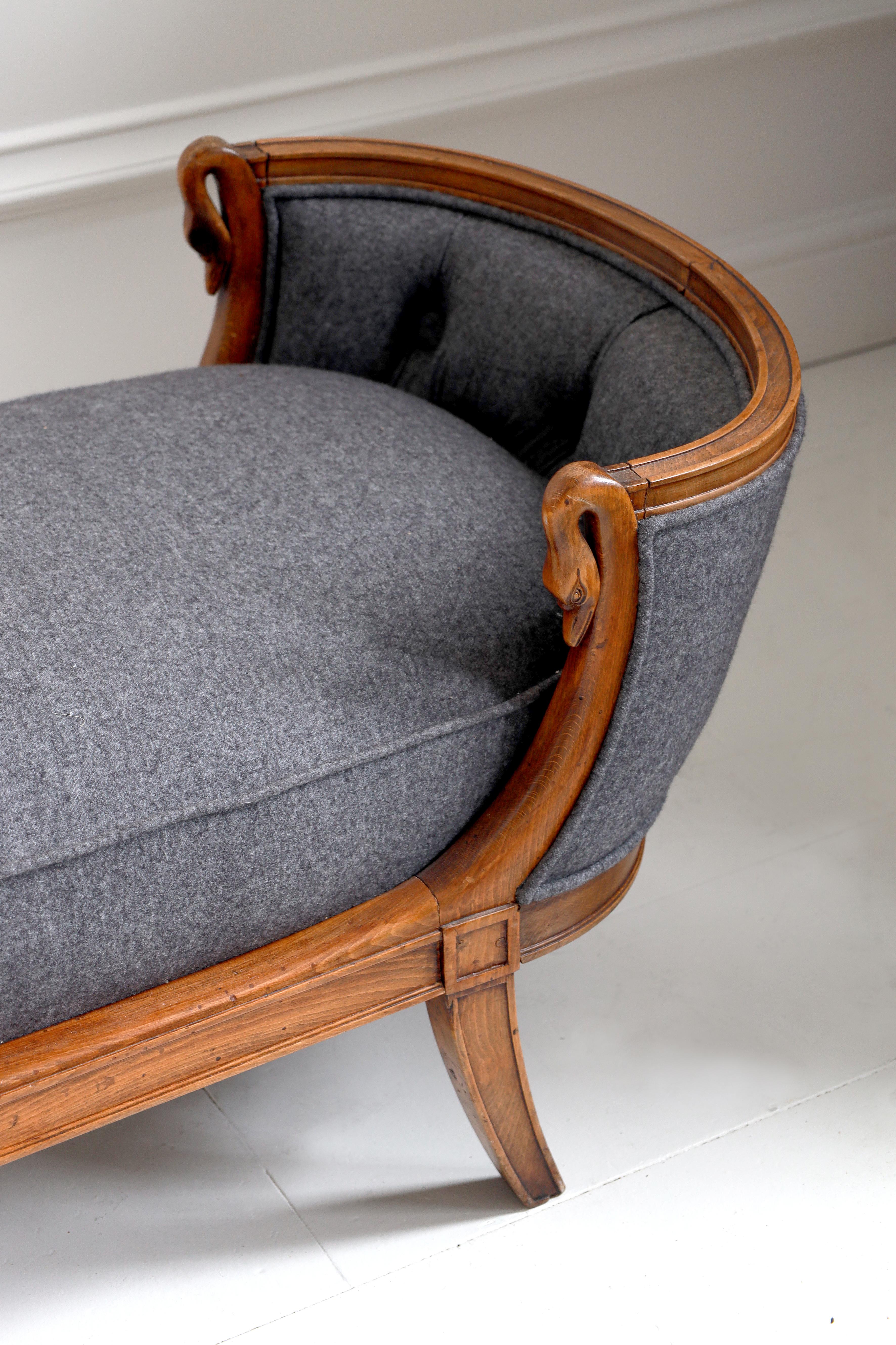 A captivating and exquisite chaise longue defined by its gracefully curved silhouette and unusual swan-neck armrests. Blending mid-century refinement with classical romance, the chaise is upholstered in a deep charcoal wool fabric with subtle tufted