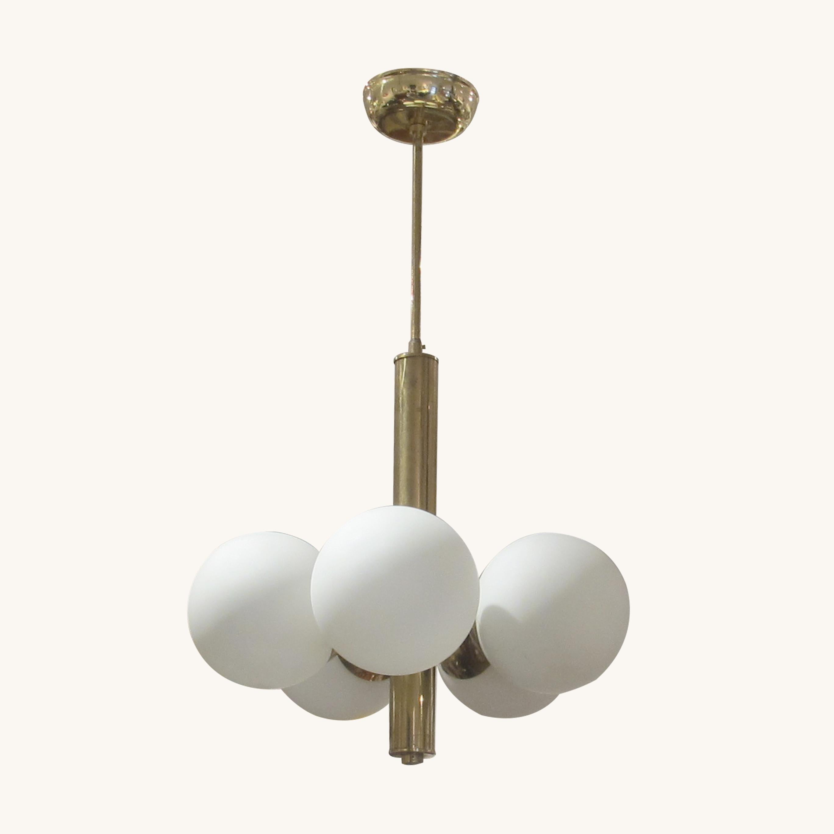 La lámpara de techo moderna de mediados de siglo se originó en Suecia hacia la década de 1950. Esta elegante luminaria presenta una columna central de latón con cinco brazos espaciados uniformemente, cada uno de los cuales sostiene un globo de