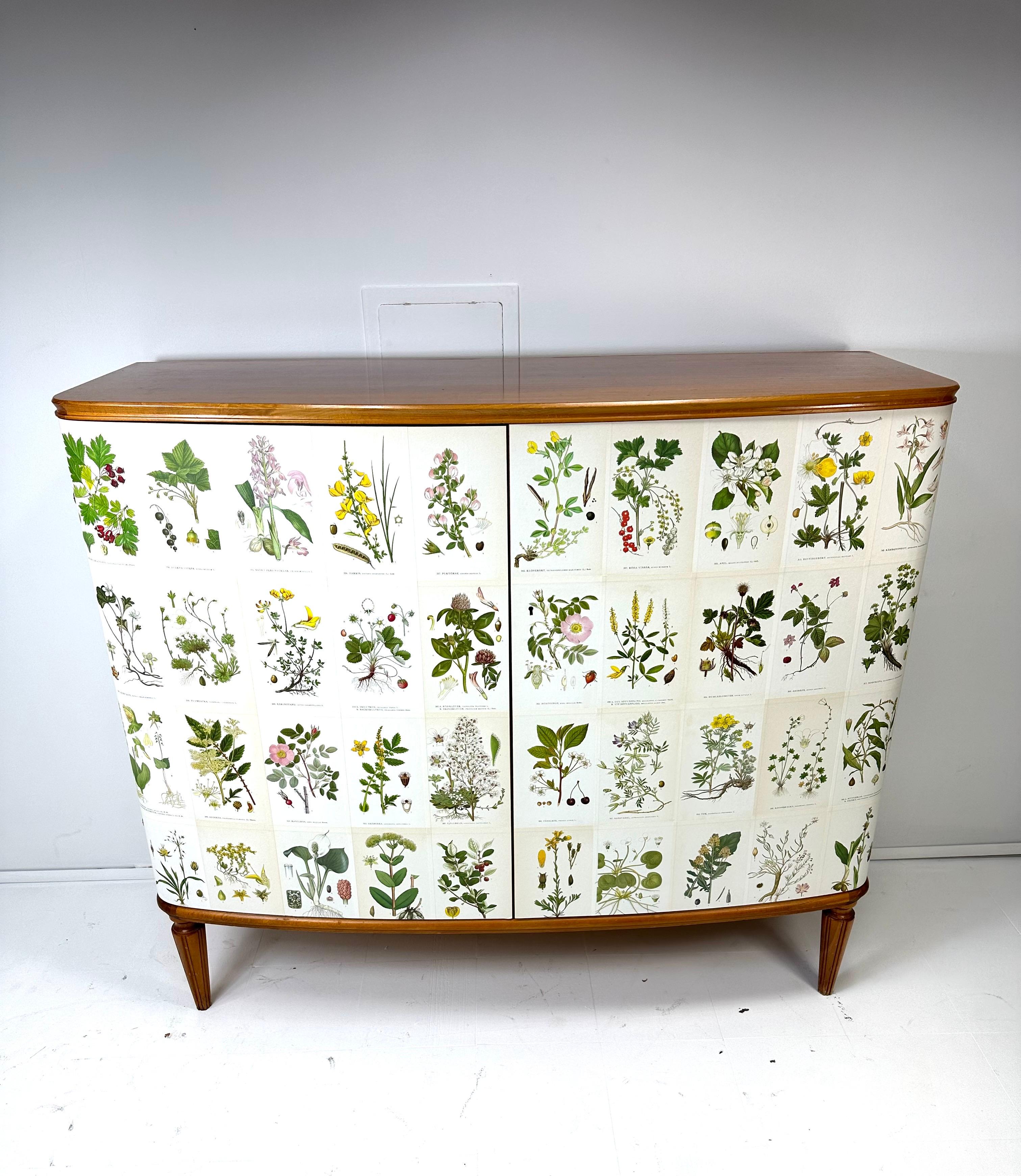1950’s bowed front Swedish Cabinet later papered with illustrations by C.A. Lindman book Nordens Flora.

Cabinet consists of 2 large doors concealing interior  shelves and small drawers.

Key included but for decorative use only.  Does not easily