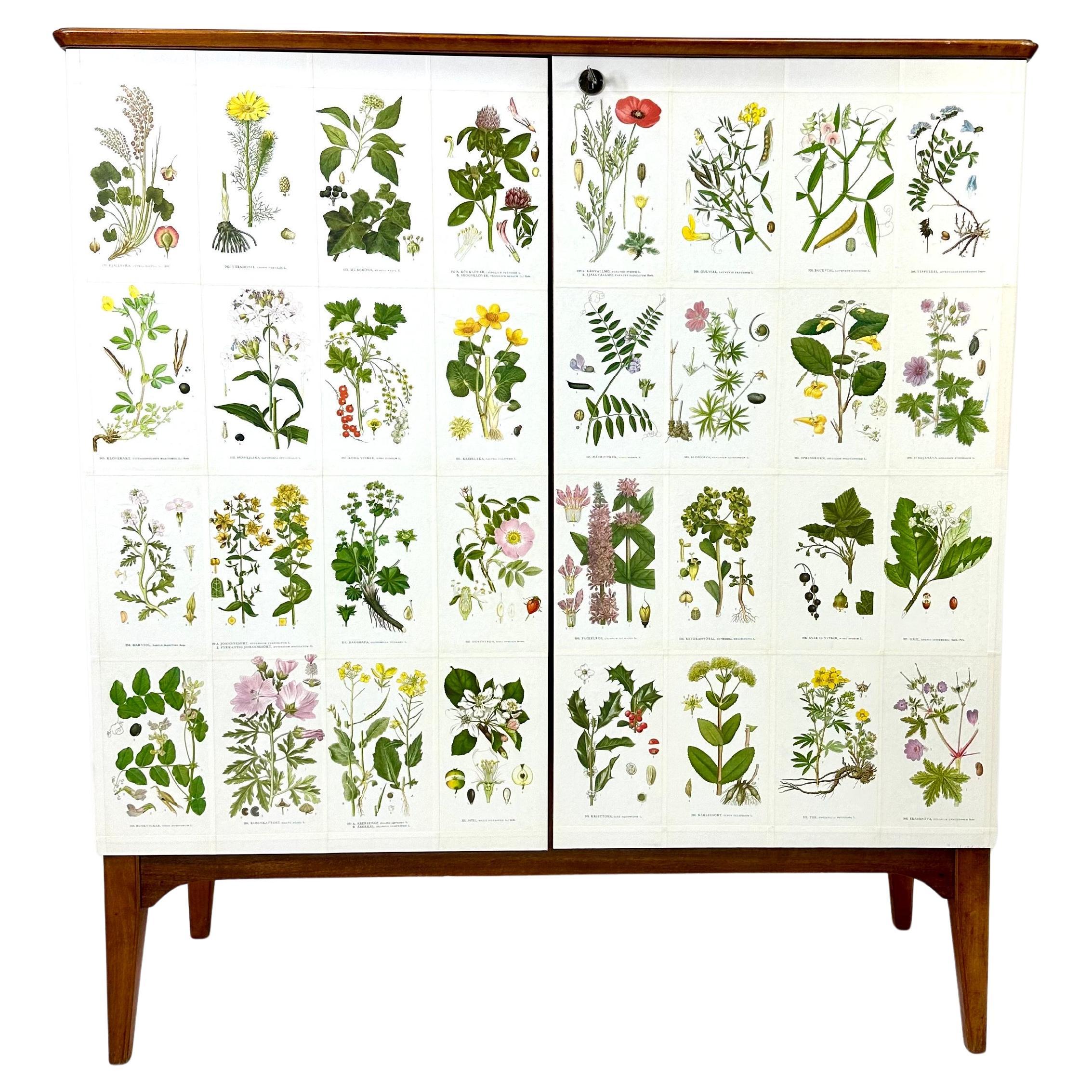 Gabinete sueco de los años 50, posteriormente empapelado con ilustraciones de C.A. Libro de Lindman Nordens Flora.

El armario consta de  grandes puertas que ocultan estantes interiores regulables y   cajones.

Llave incluida.