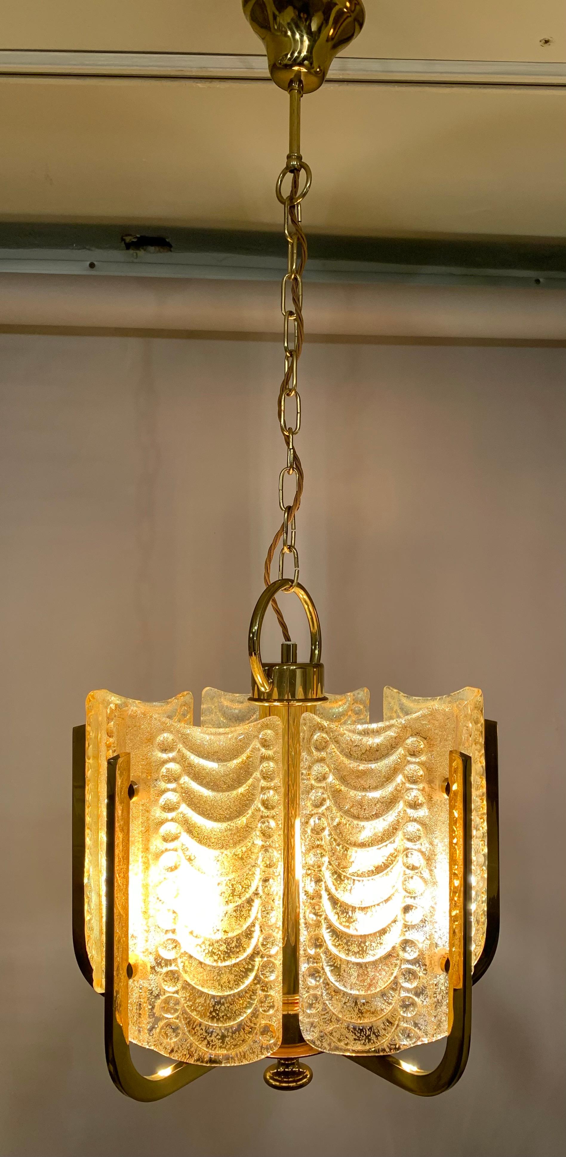 1950s Swedish chandelier designed by Carl Fagerlund for Orrefors. The light is designed with five thick gold-tinted textured glass fins, with a garland design, which screw internally onto the polished brass frame. Each fan is wonderfully textured on