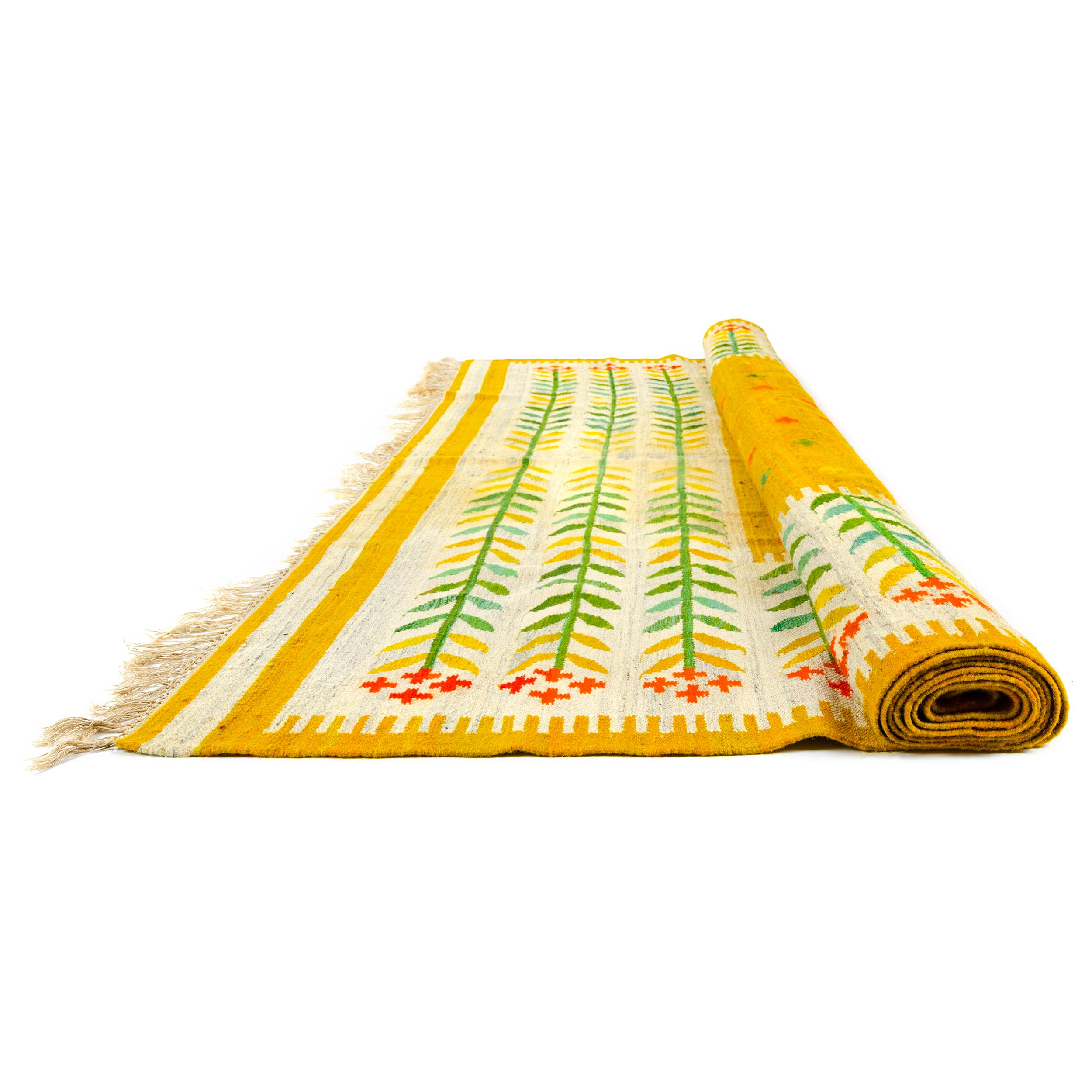A colorful handwoven wool rug with a bright botanical motif.