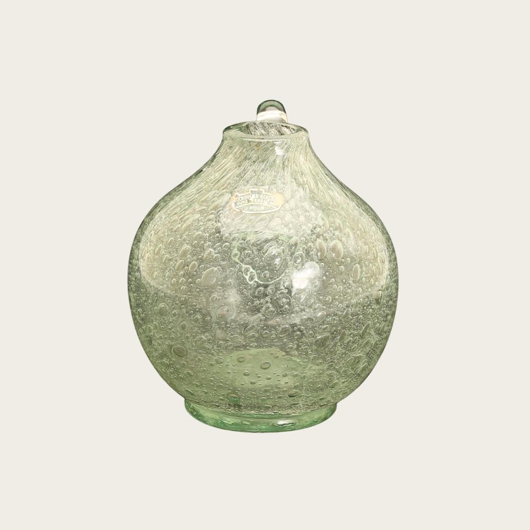 This 1950s Swedish handblown sea foam glass pitcher by Ture Berglund features distinctive glass bubbles throughout, adding unique texture and character. A designer label is affixed to the front, confirming its authenticity and craftsmanship.