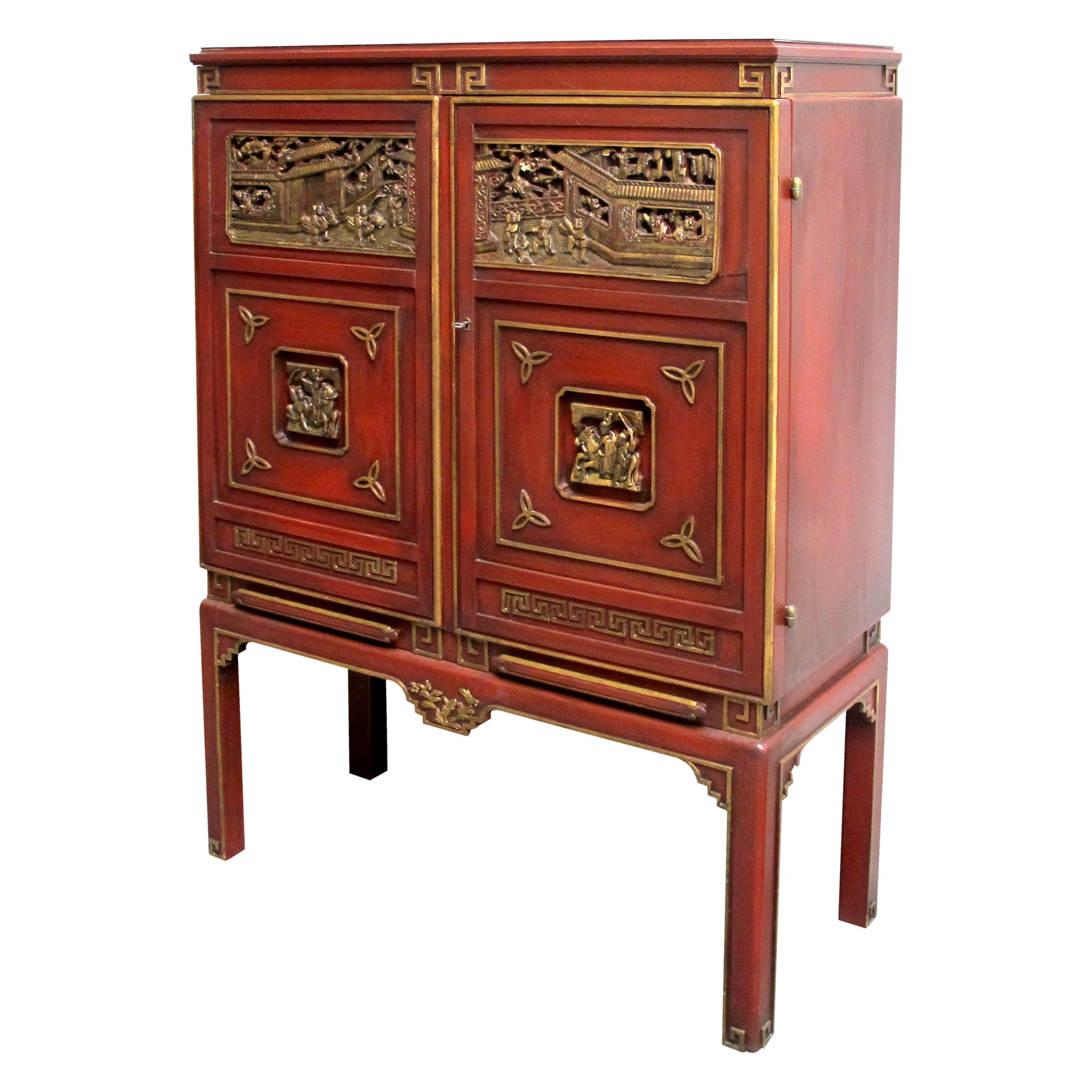 This elegant Chinese-style drink cabinet from the 1950s offers a beautiful blend of traditional craftsmanship and mid-century design. Original deep red painted wood, the cabinet is adorned with intricate gold detailing that highlights its elegant