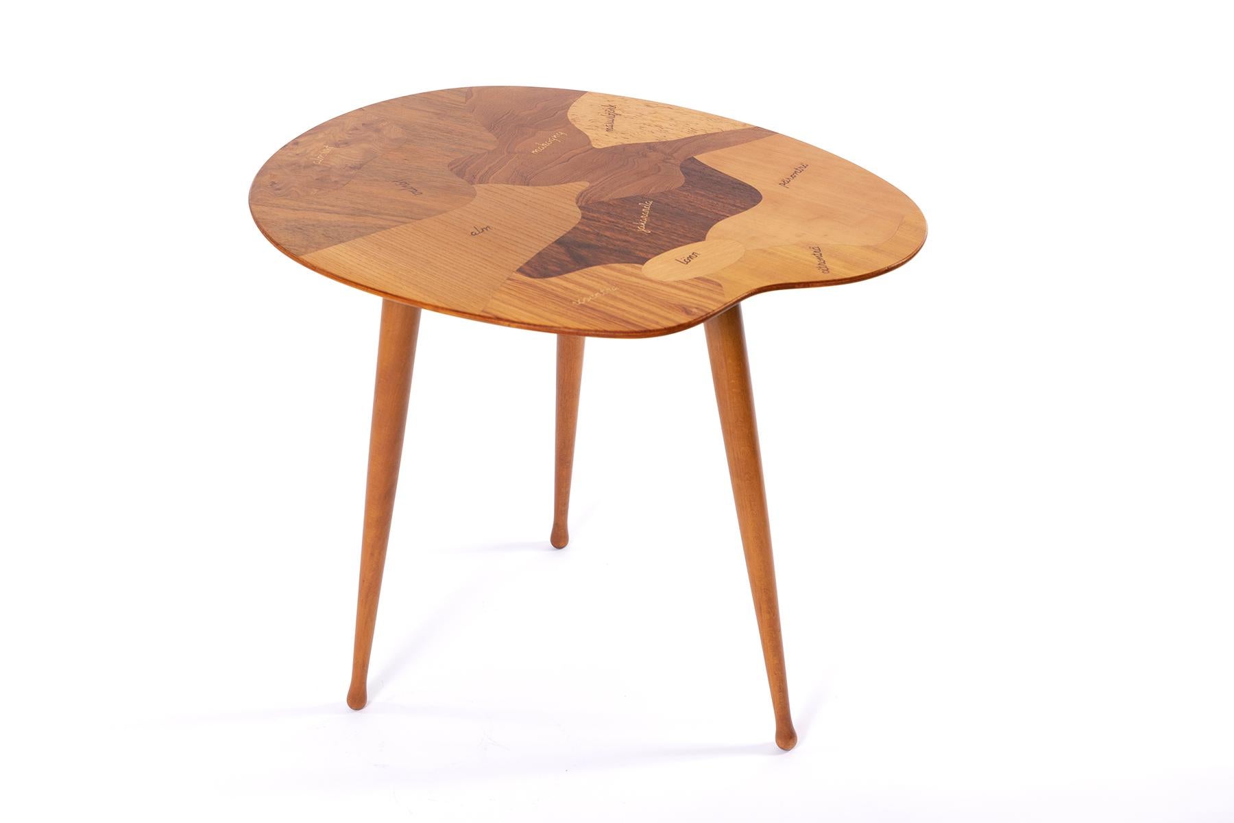 Painters palette side table in a variety of woods playfully listed and displayed in Swedish. Legs are easily removable.