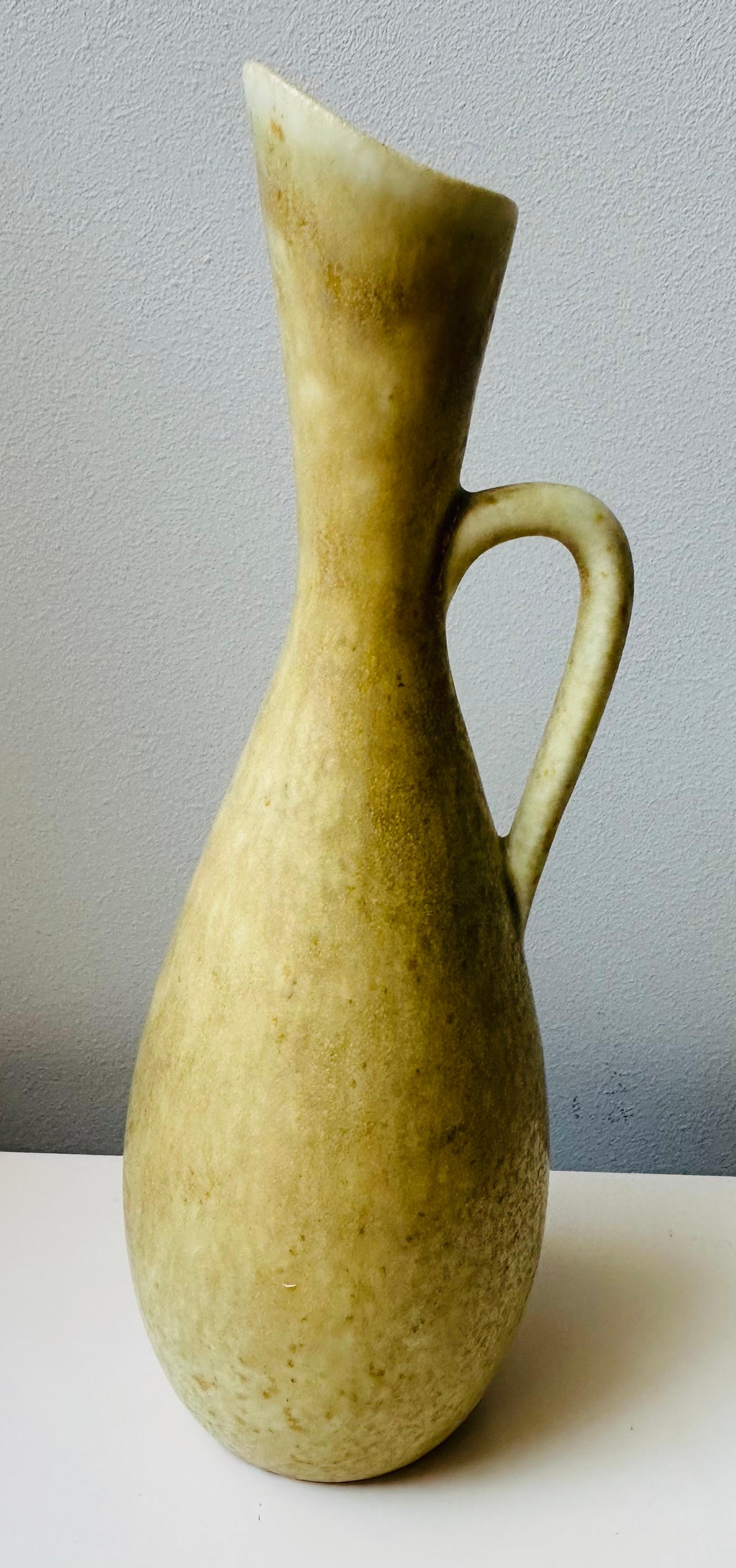 A beautiful mottled-yellow 1950s Swedish handle-jug designed by Carl-Harry Stålhane for the Rörstrand Factory.  The pottery, stoneware jug, features a wonderful smooth and tactile glaze in subtle marble effect yellow tones.  Inscribed on the base: 
