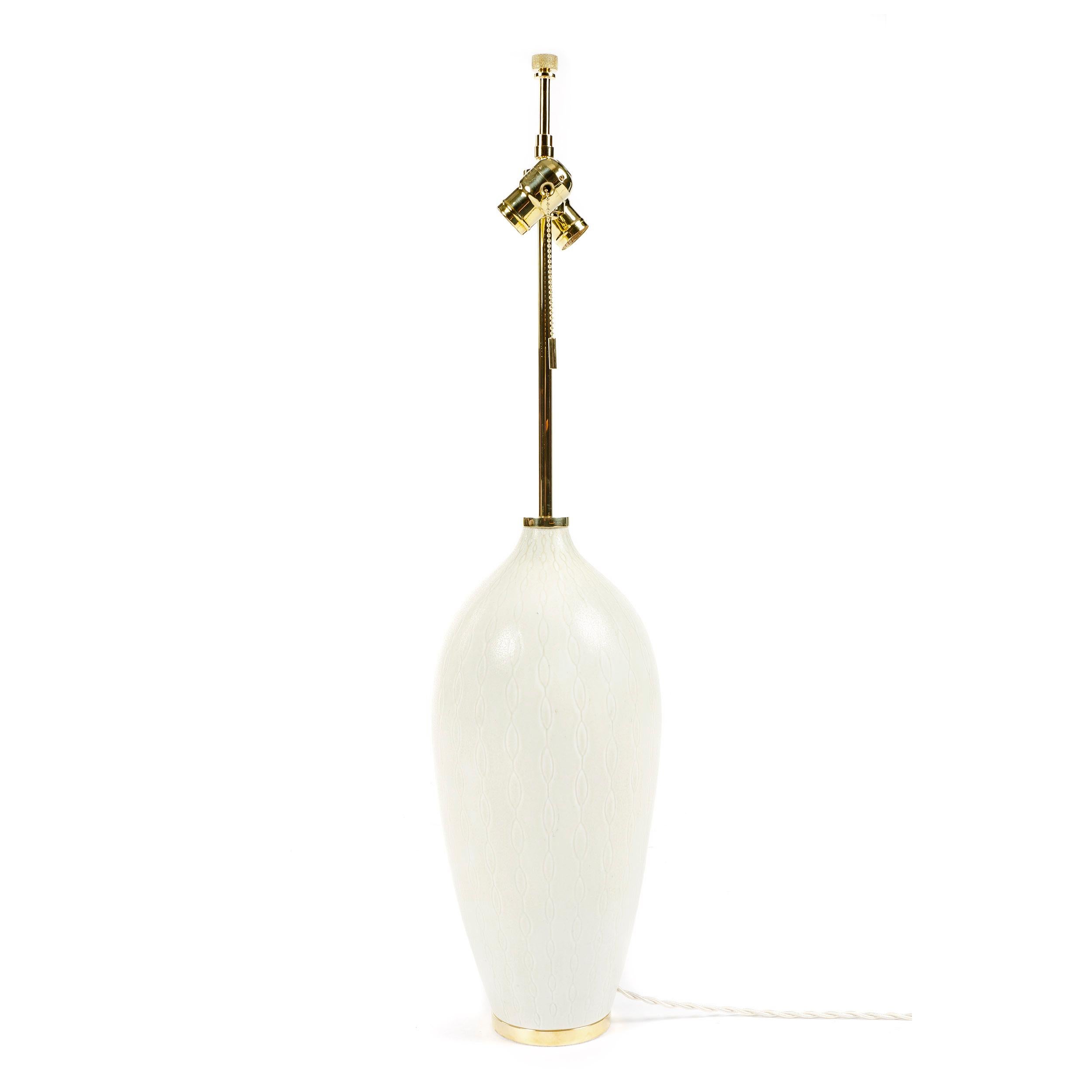 Monumentale lampe de table en grès Rorstrand du maître céramiste suédois Carl Harry Stalhane. Le corps en grès blanc présente une glaçure mate blanc cassé modelée avec un motif répétitif sous glaçure consistant en une série verticale d'ovales