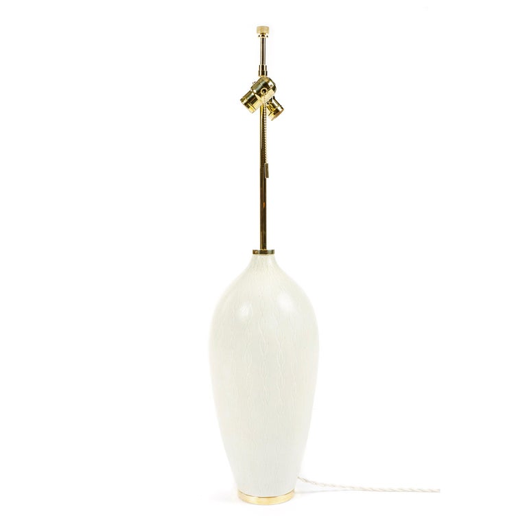 Monumental Rorstrand stoneware table lamp by Swedish master ceramist Carl Harry Stalhane. The white stoneware body exhibits an off-white matte glaze modeled with a repeating underglaze design being a vertical series of slightly impressed elongated