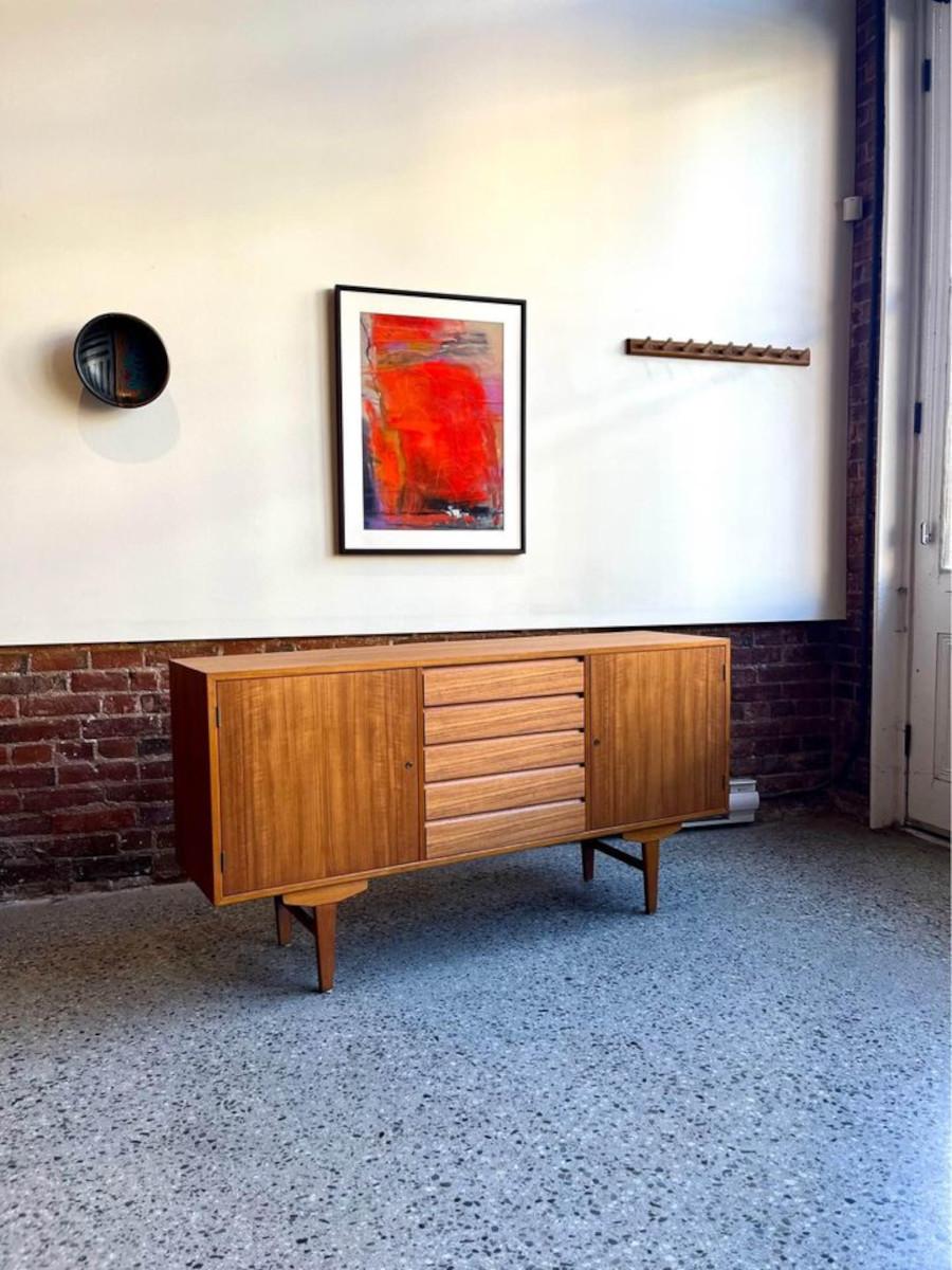 Introducing this captivating 1950s Swedish teak and beech credenza, perfect for small-scale living spaces. This charming piece, enhanced with a tastefully finished back which was added during the 1960s, offers a touch of mid-century sophistication