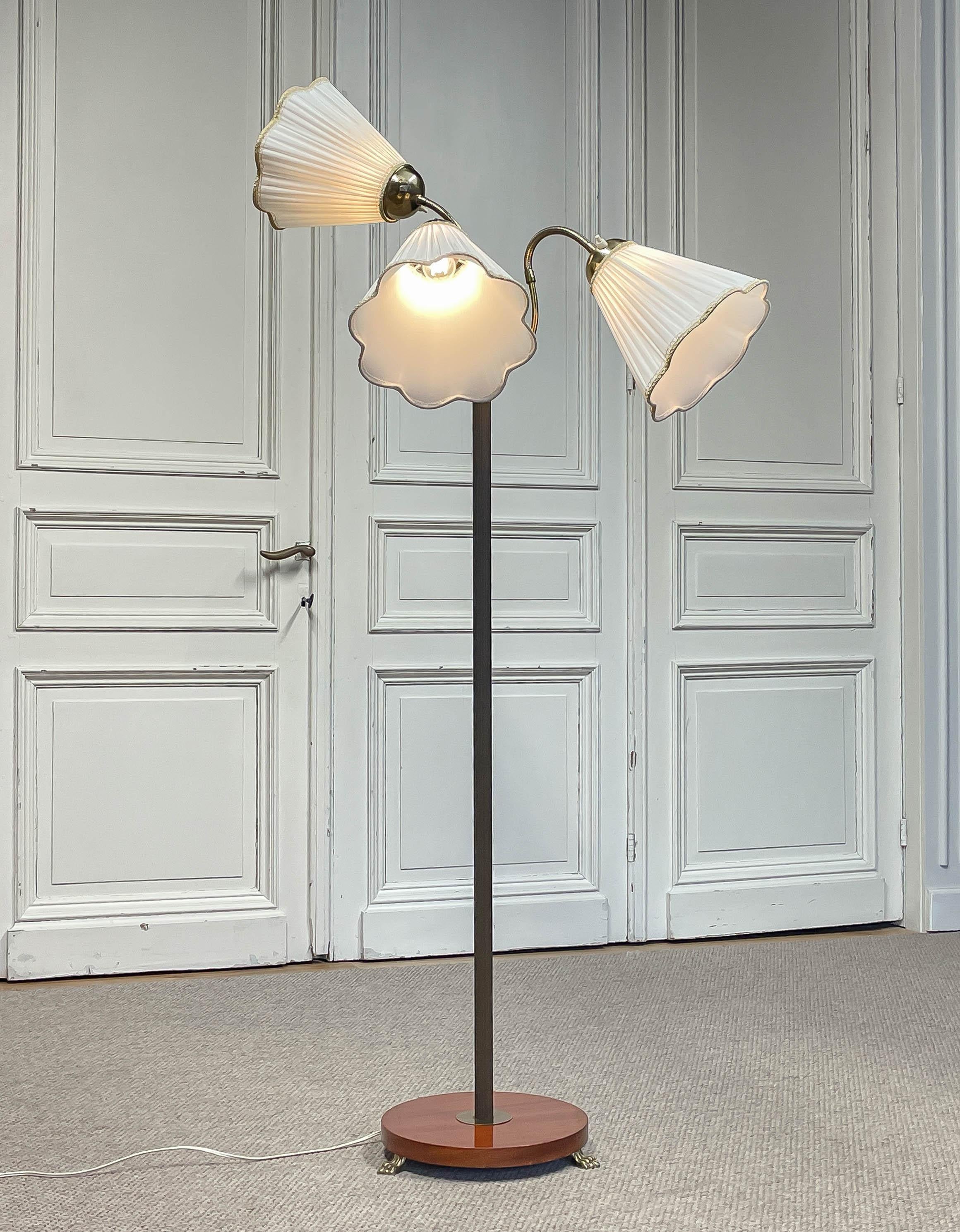 Design-Light élégant du milieu du siècle, avec trois abat-jours plissés en tissu blanc, chacun contrôlé individuellement pour un éclairage réglable.
Les abat-jours sont montés sur un luminaire en laiton aux bras gracieusement incurvés, soutenu par