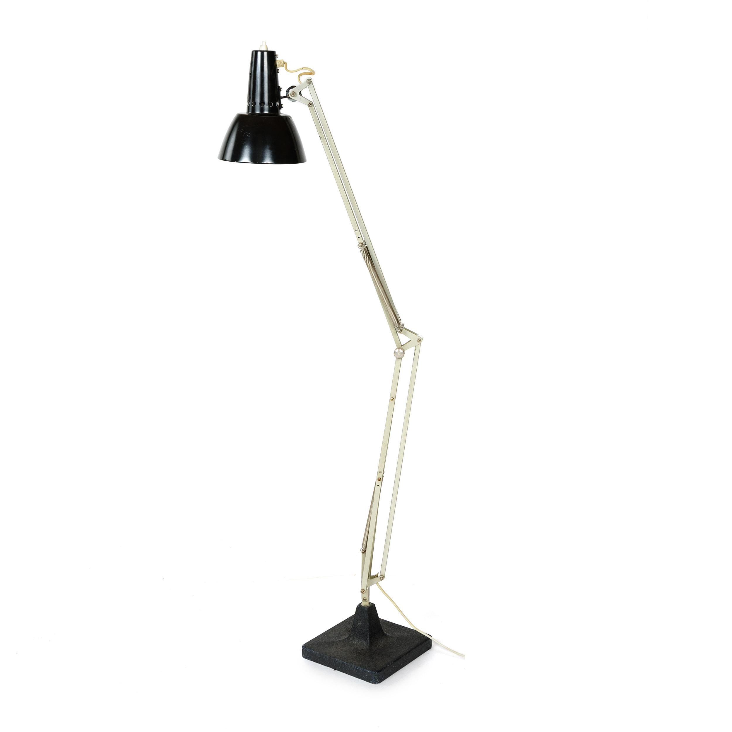 An articulating, all metal spring tension task lamp capable of nearly unlimited positioning via two elbow joints, end knuckle, a swiveling shade joint as well as the entire arm mechanism rotates 360 degrees atop a heavy cast metal base with a black