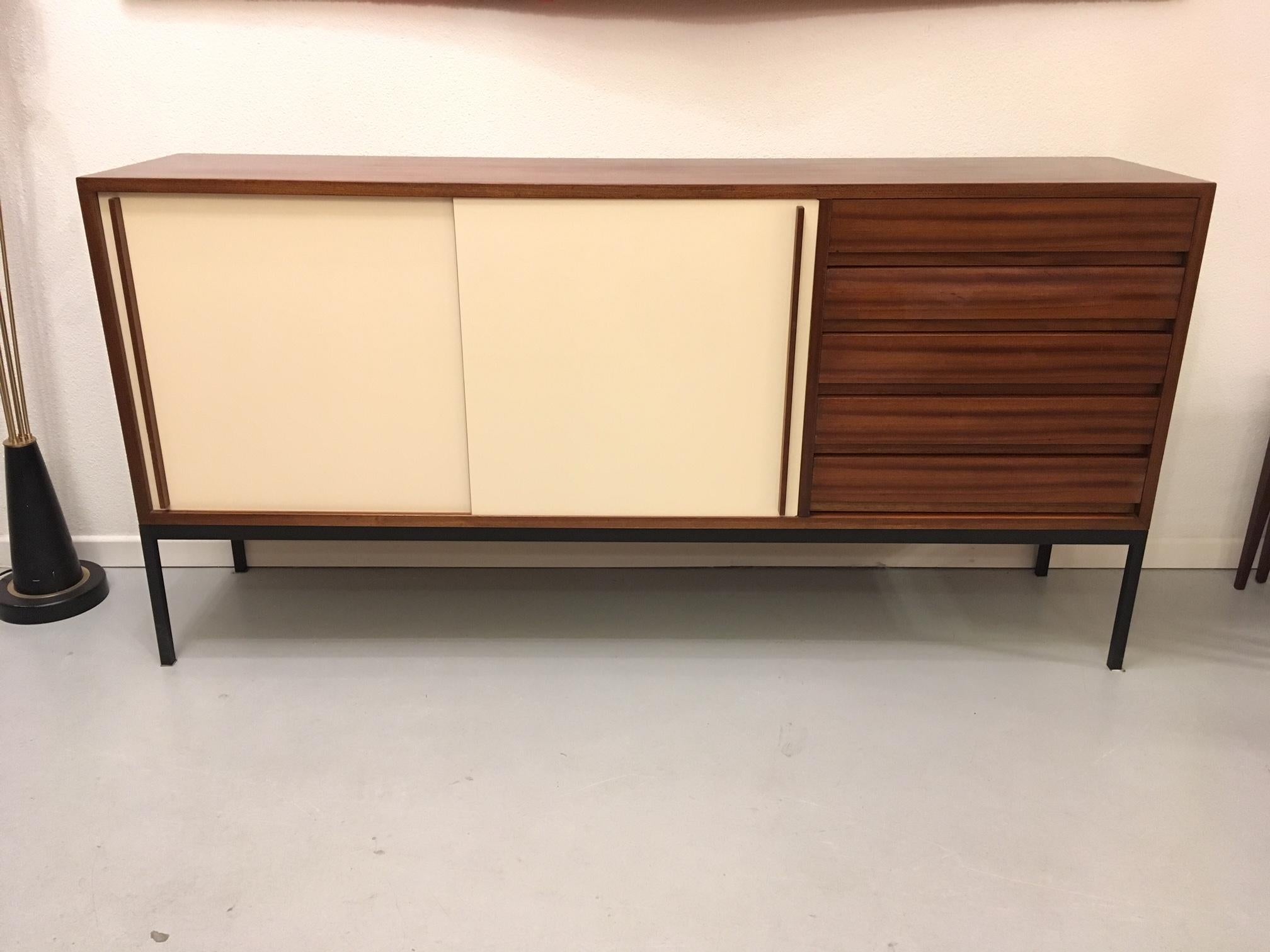 Swiss mahogany sideboard made by Victoria AG, circa 1950s
2 whites sliding doors, 5 drawers, black painted metal base
In the style of Charlotte Perriand.