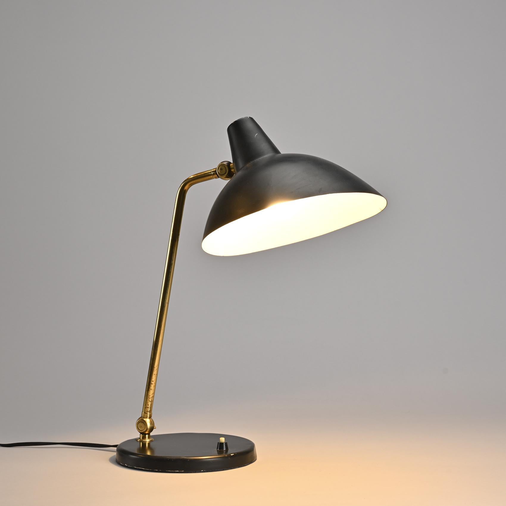 Desk lamp model Adria designed in the 1950s by Alfred Müller for Amba.

The black-lacquered metal base houses an adjustable stem with two gilded brass ball-and-socket joints and a black-lacquered metal reflector cap.

Manufacturer's