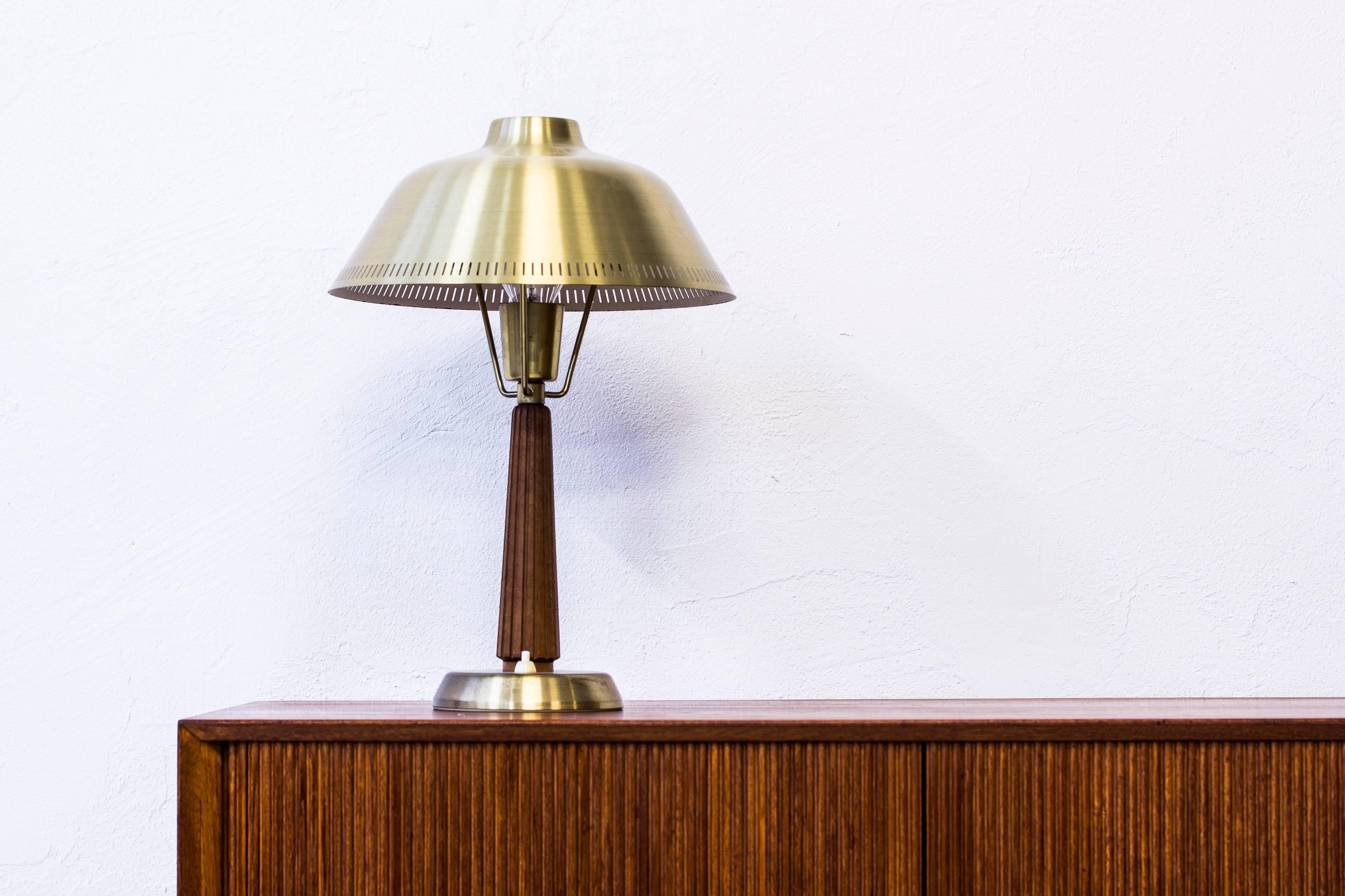 Table lamp model E1149 designed by Hans Bergström. Produced in Sweden by ASEA Belysning during the 1950s. Made from solid mahogany and brass. Light switch on the table lamp base in working order. Excellent condition with few signs of wear and light