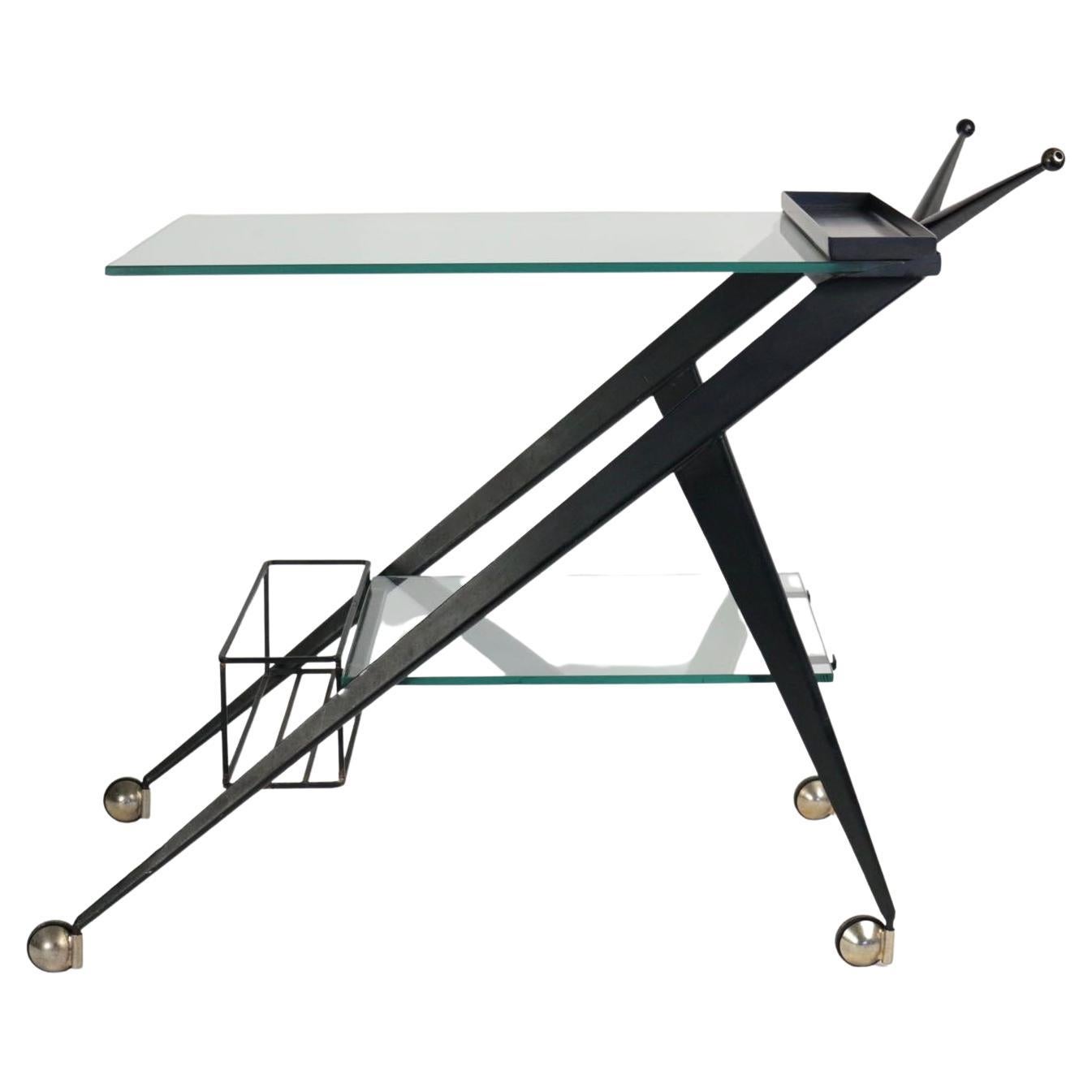 1950s table on wheels by Angelo Ostuni.
A typical table on wheels with bottle holder, black lacquered folded metal based and handles decorated with amazing V-folded metal with a ball finish.
