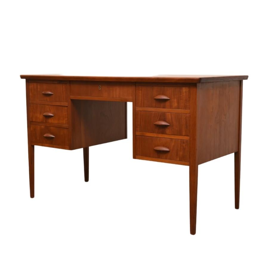 A beautifully crafted Mid-century teak desk designed by Niels Christensen Jun in Denmark during the 1950's. 

Constructed from warm, richly grained teak, the desk features clean lines, slender tapered legs, and practical storage with three drawers