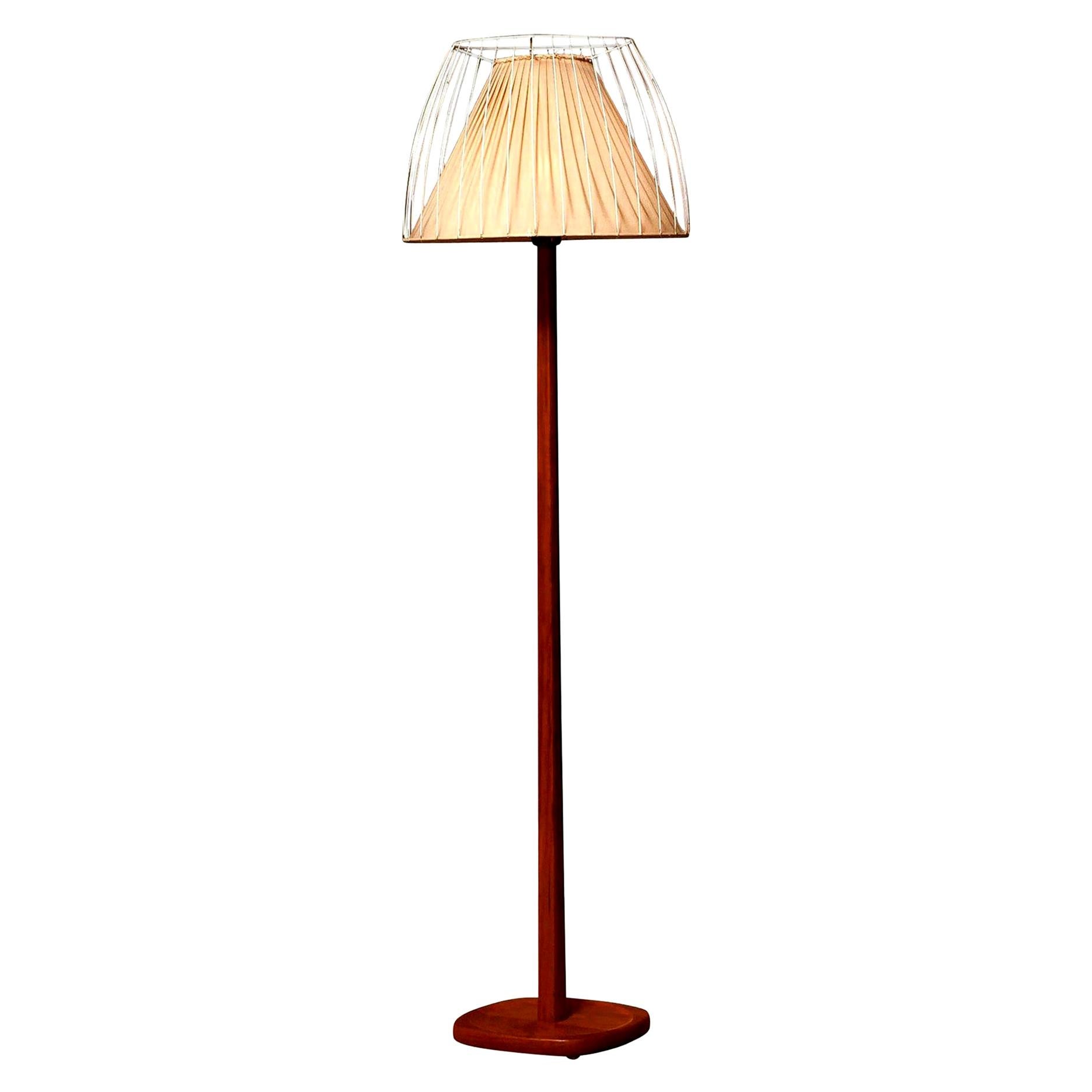 Very beautiful floor lamp made by Stilarmatur, Sweden.
This lamp has a wonderful shape shade that consists of a fabric shade on the inside and an open metal white lacquered shade on the outside on a very nice teak stand.
It is in a nice and