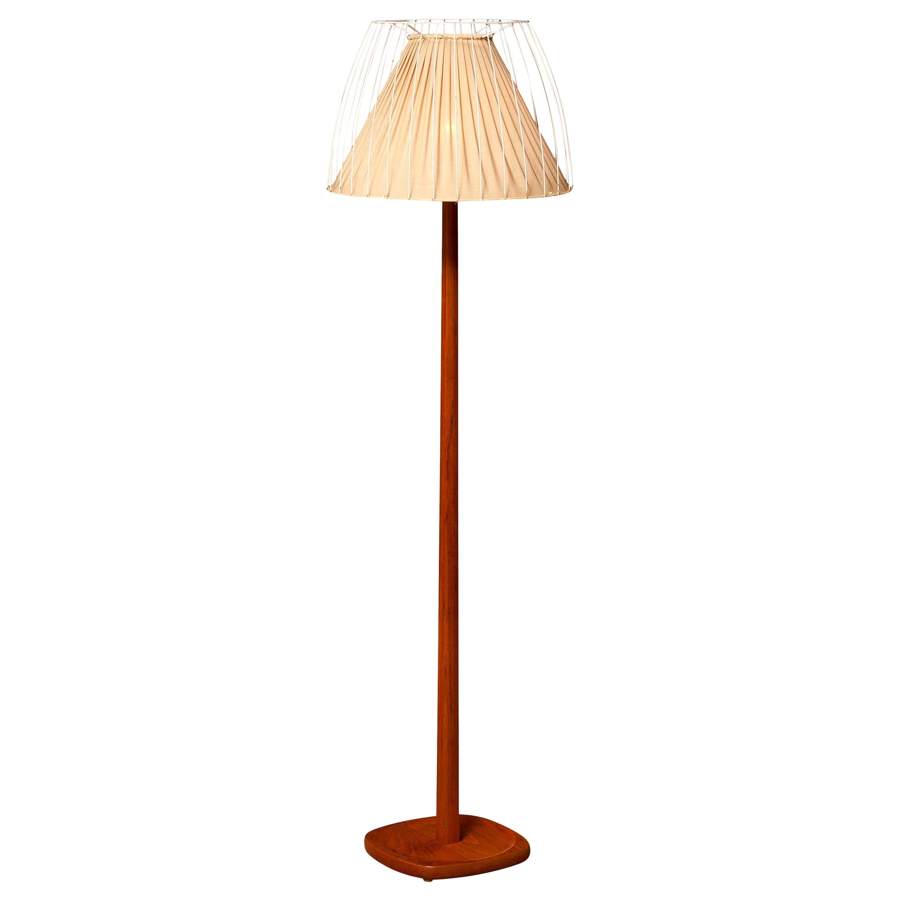 Very beautiful floor lamp made by Stilarmatur, Sweden.
This lamp has a wonderful shape shade that consists of a fabric shade on the inside and an open metal white lacquered shade on the outside on a very nice teak stand.
It is in a nice and