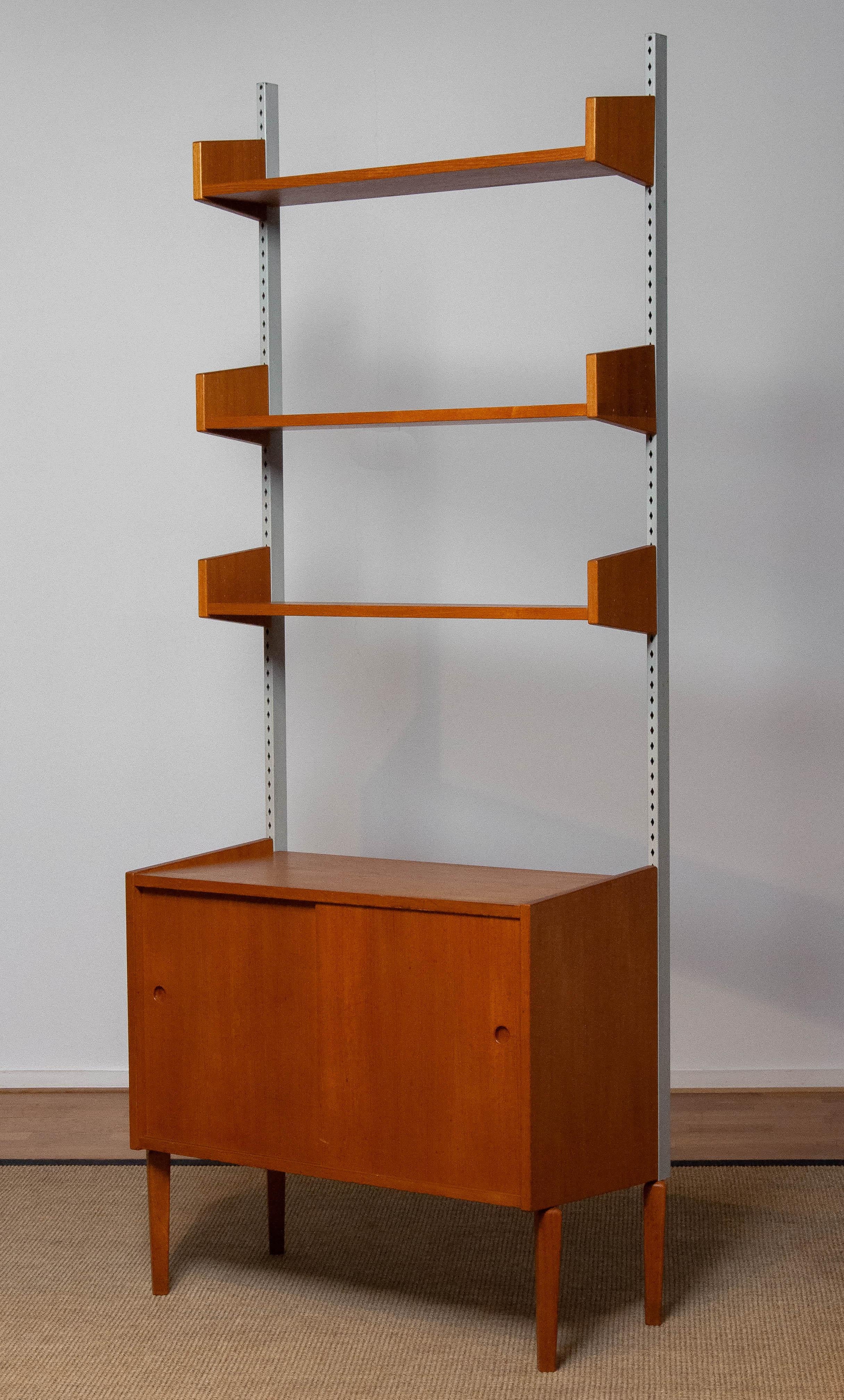Magnifique et extrêmement rare système d'étagères modulair conçu par Harald Lundqvist pour Lizzy Element Möbel Suède dans les années 1950. Les trois étagères sont réglables en hauteur. L'armoire est dotée de deux portes coulissantes et d'une étagère
