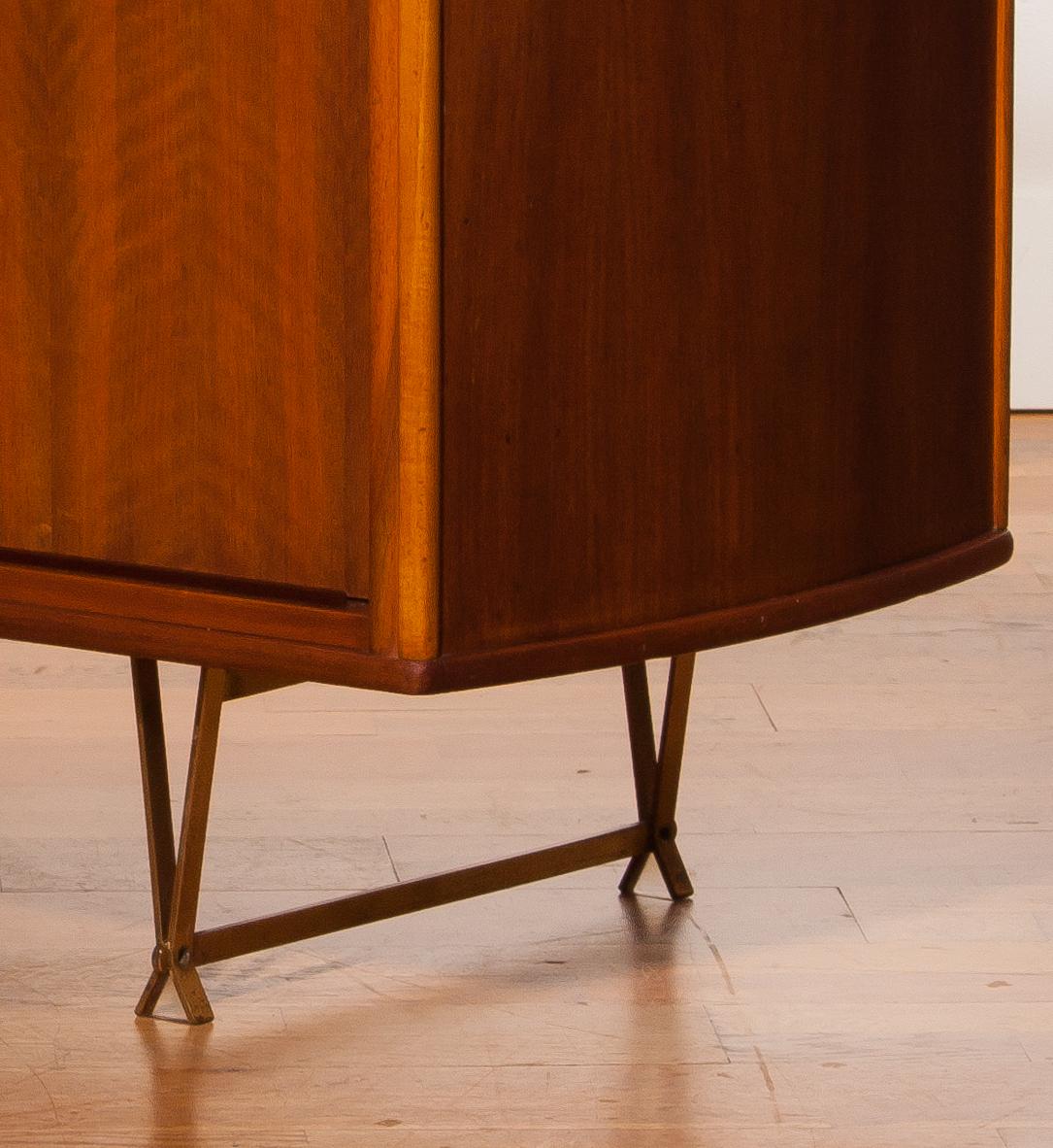 Beautiful unique sideboard designed by William Watting for Fristho.
The cabinet is made of teak wood with brass legs.
The sideboard has two sliding doors and five drawers with at the top two different sizes.
And beneath three large