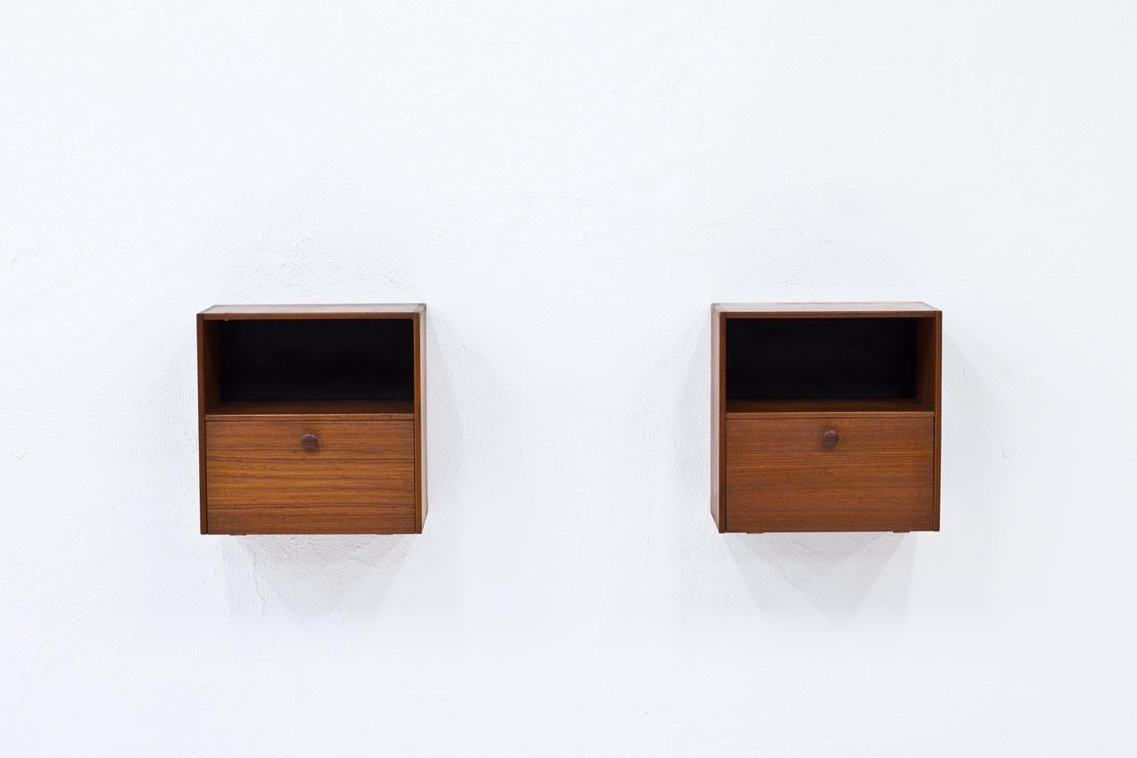 Neat pair of wall–mounted night stands designed by Nils Jonsson. 
Manufactured by Hugo Troeds in Sweden during the 1950s.
Made from teak with black laminate background. 
Box joint construction.