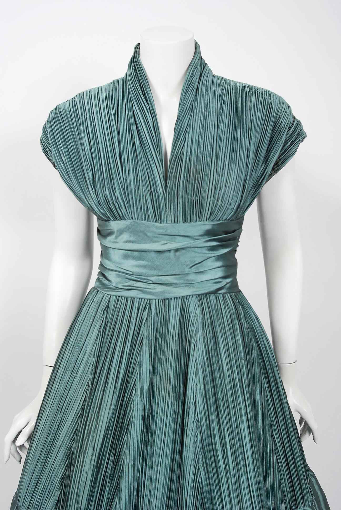 Fashioned from vibrant teal blue light-weight silk, this 1950's 
