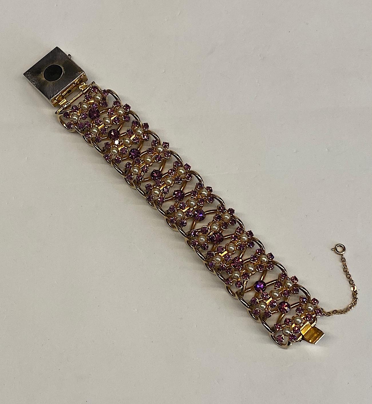 A 1950s unusual, three dimensional and large gold tone large link statement bracelet with purple rhinestone accents. The bracelet consist of large .58 inch wide by 1.13 long and .58 inch high links made of thick metal wire or cord. Not only is the