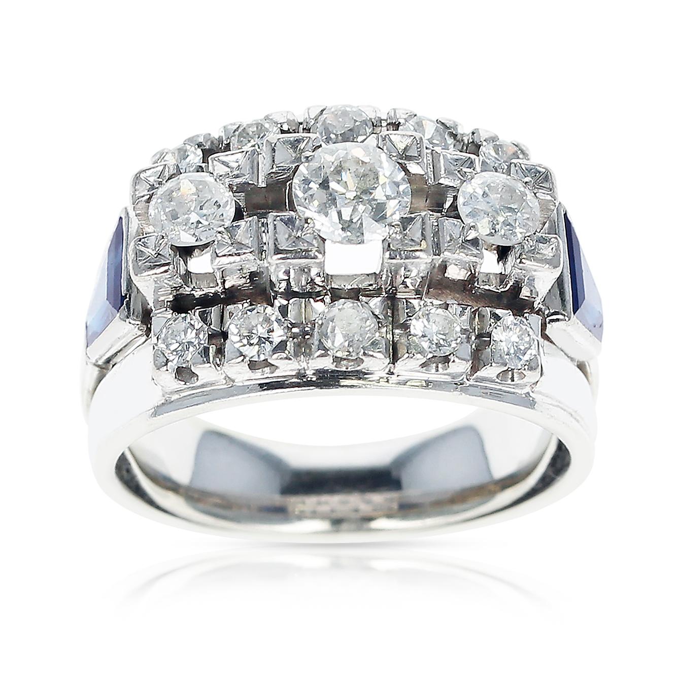 A 1950s Bold and Prominent Diamond Ring with Thirteen Round Diamonds accented with Two Sapphire Trapezoids made in 18 Karat White Gold. Ring Size US 7.75. Total Weight: 11.63 grams. 
The three round diamonds are 0.85 carats total, and the accenting