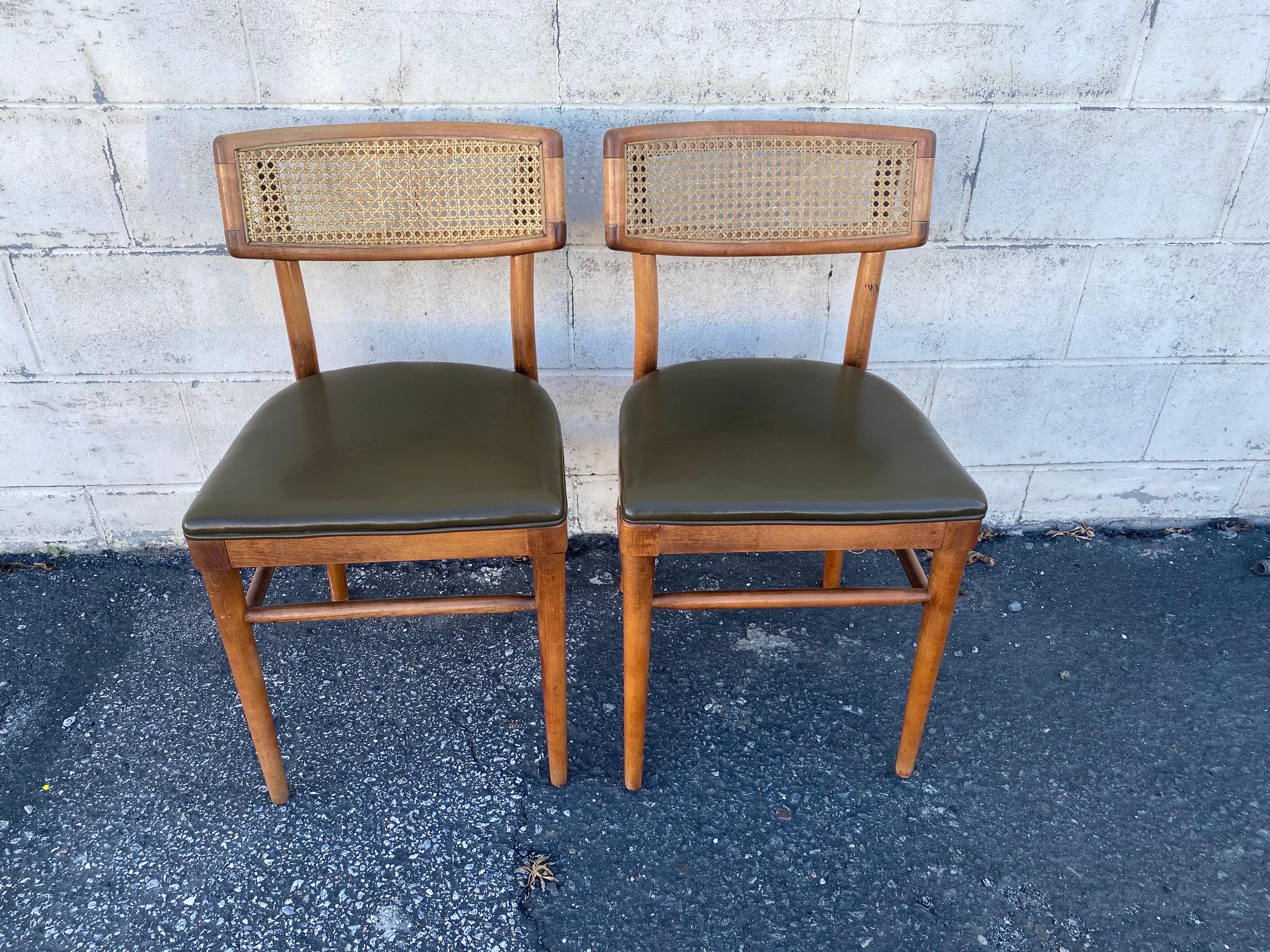 Fantastic pair of bentwood dining chairs with the original dark green vinyl upholstery and cane back made by Thonet in the 1950s. A true testament to it's time, both in craftsmanship and design. 

Both chairs are in excellent structural condition