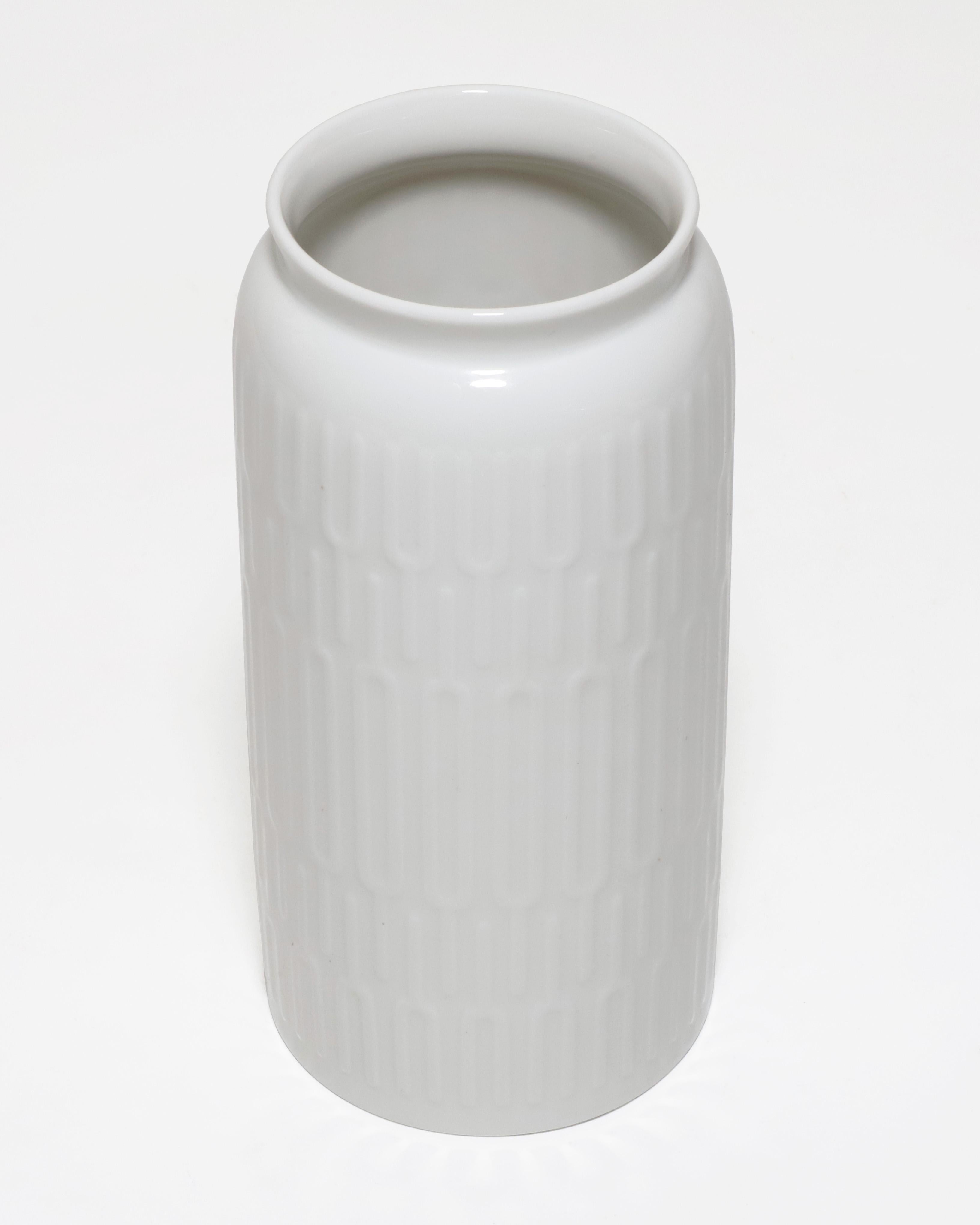 Royal Copenhagen 4218 white vase with relief designed by Thorkild Olsen in the 1950s. Beautiful minimal modern pattern design around the vase. A perfect flower vase for a table center decoration. 

Property from esteemed interior designer Juan