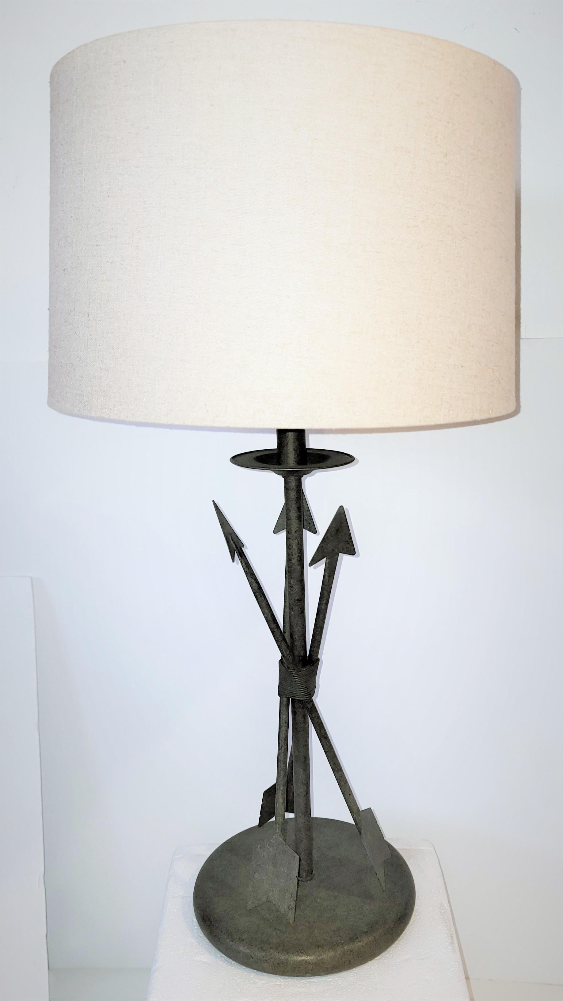 1950's Three arrow table lamp. 
The lamp has three arrows pointing upward into the light. The green patina is great. 
The shade measures 14 in diameter x 9.5 in height.
The light measures 28 in height and 8.5 in diameter.