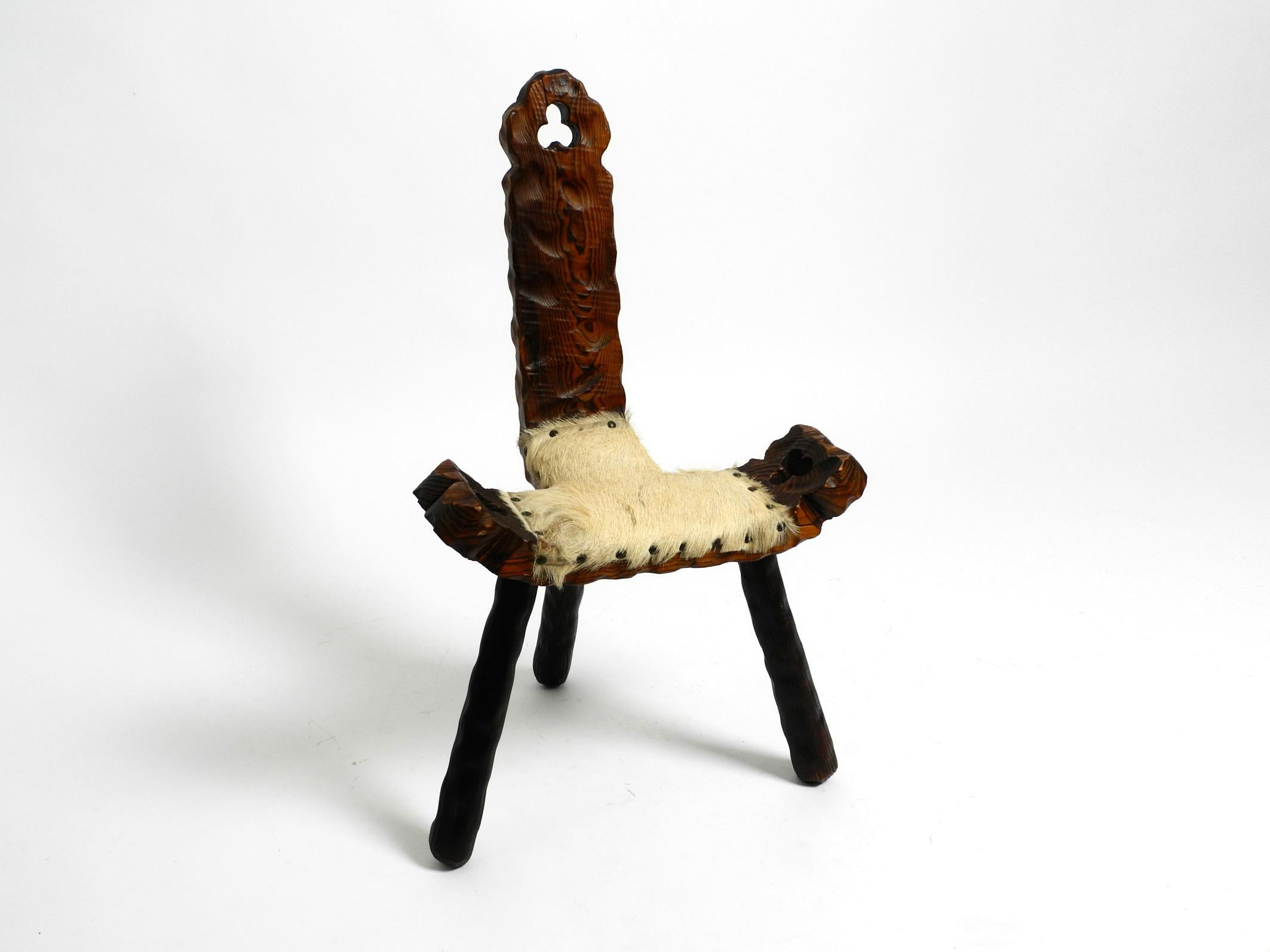 Magnifique tabouret tripode Mid Century avec dossier en bois de pin massif de couleur noir-brun.
L'assise est recouverte de cuir de vache et rivetée.
Sculpture artisanale de haute qualité avec de nombreux détails
Condition vintage intacte.
Pas de