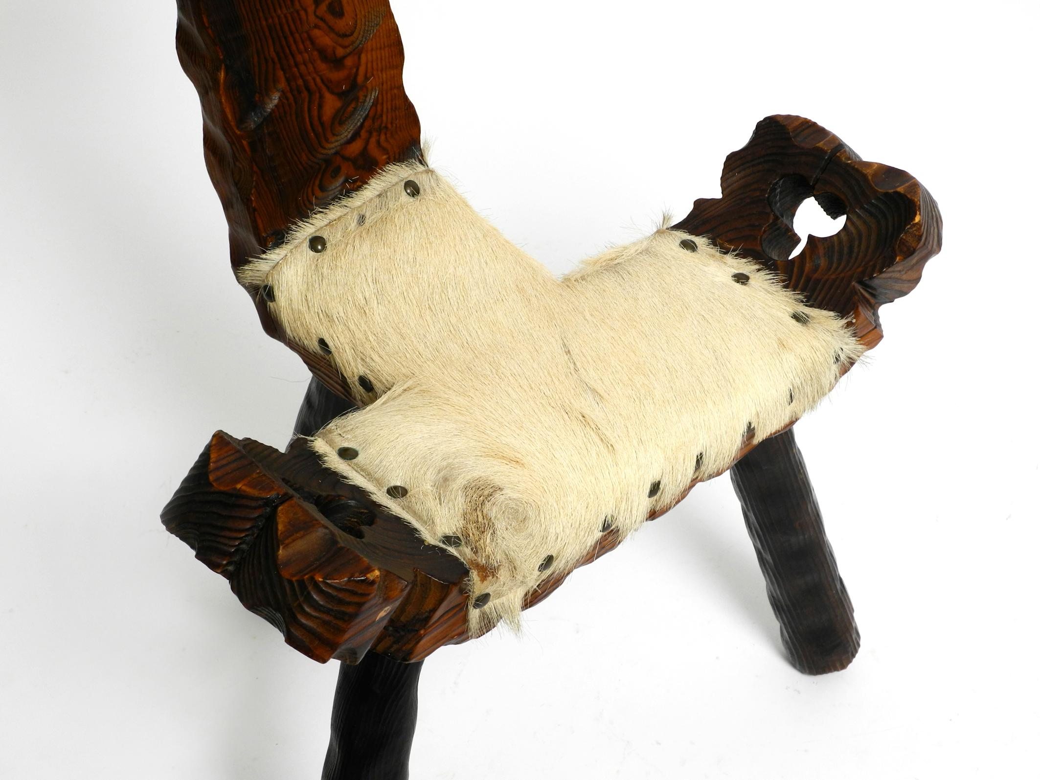 1950s three-legged stool made of solid wood in black-brown with cowhide seat In Good Condition For Sale In München, DE