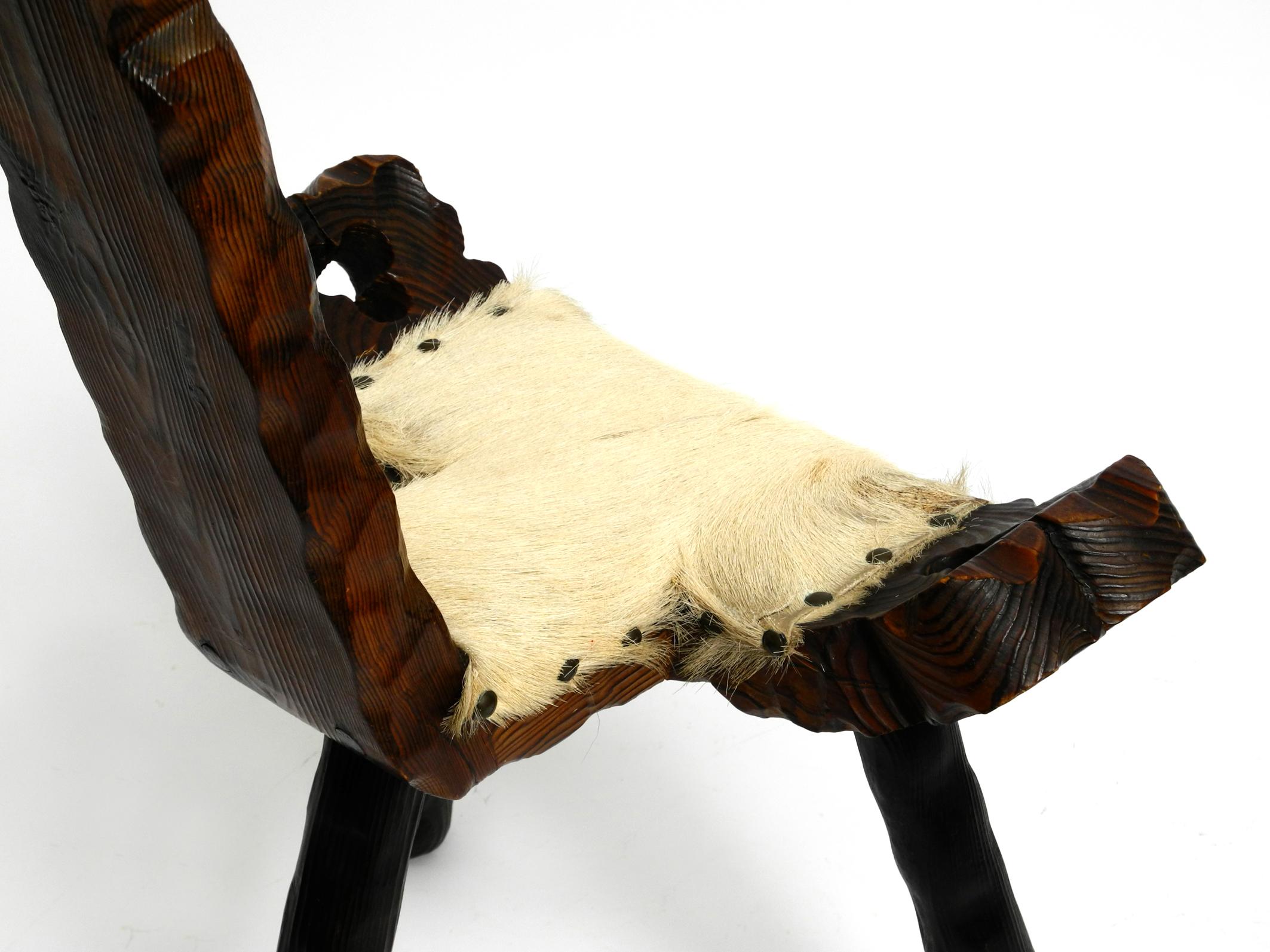 Mid-20th Century 1950s three-legged stool made of solid wood in black-brown with cowhide seat For Sale
