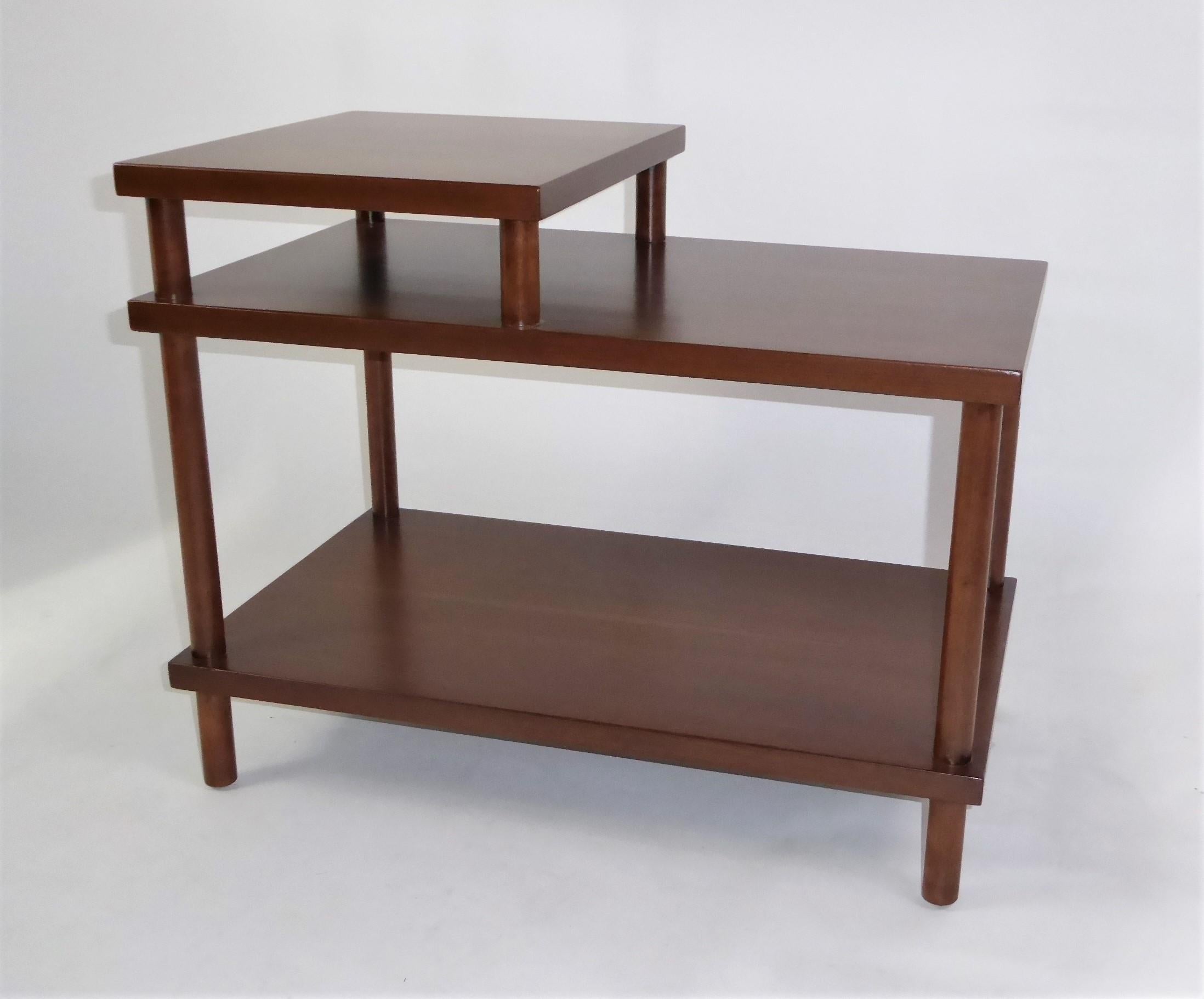Early 1950s side table by T. H. Robsjohn Gibbings for Widdicomb. Restored finish to the walnut table with a stepped form with rounded dowel supports. Beautiful figured wood. We like it displayed from the side. Retains Widdicomb cloth label with