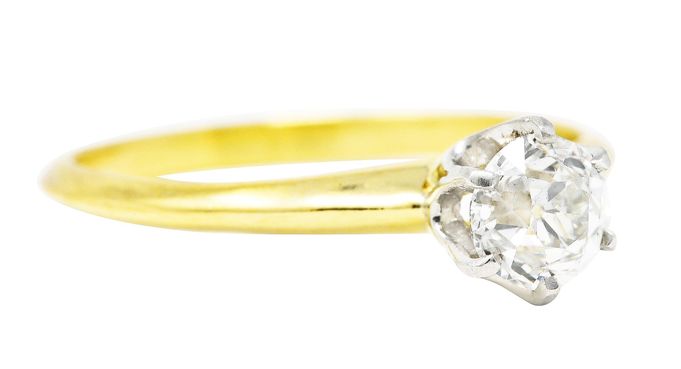 Solitaire ring features an old mine cut diamond weighing approximately 0.58 carat - H color with VS2 clarity. Set in a stylized six prong platinum head. Completed by a knife edged yellow gold shank. Stamped for platinum and 18 karat gold. Fully