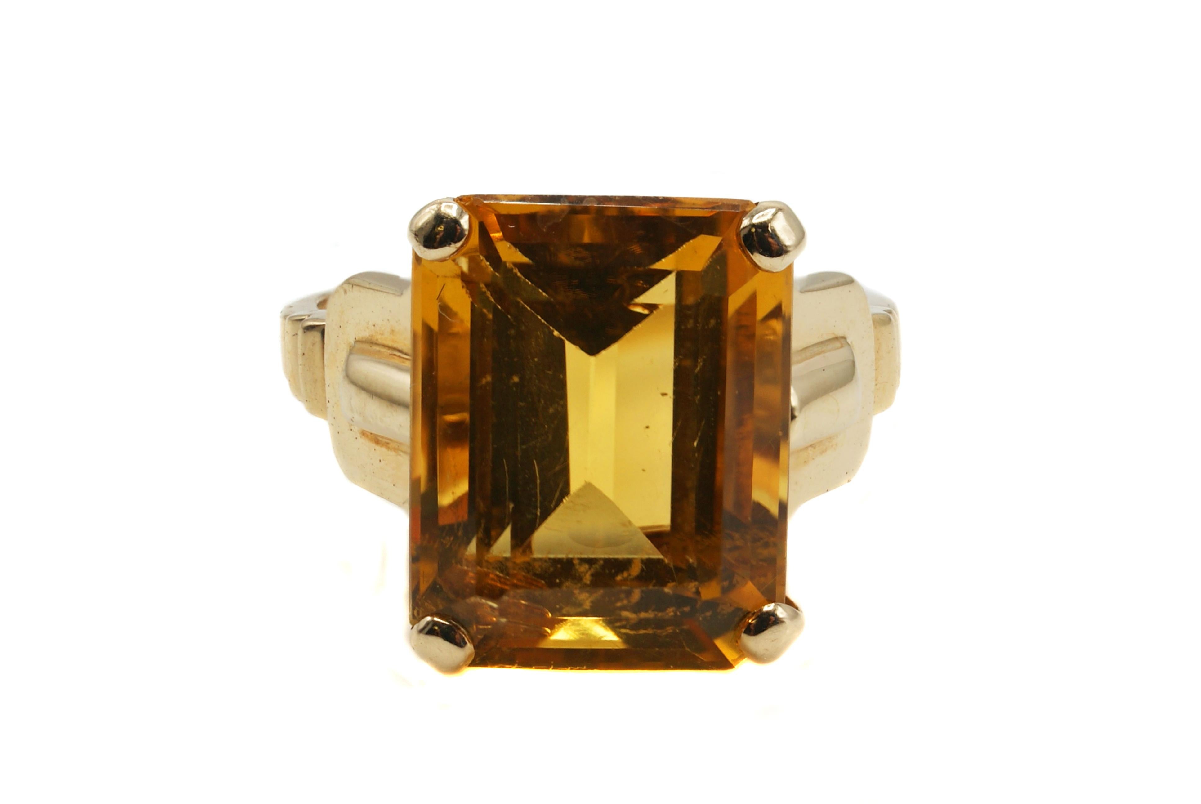 Stunning bright orange emerald cut citrine retro ring by Tiffany & co. set in a handcrafted 14 karat yellow gold mounting. The beautiful saturated orange color of this well cut citrine is complimented by just the right tone of the yellow gold to
