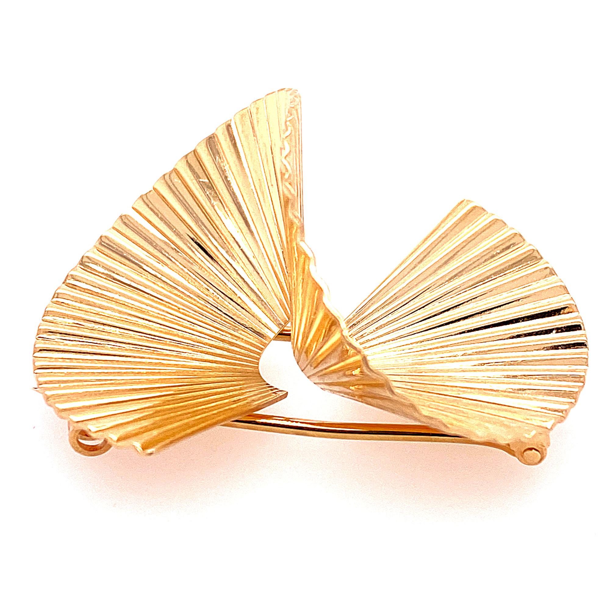 1950's Retro swirl pin by Tiffany & Co. The ribbed pin is fashioned in 14 karat yellow gold and measures 1.75 x 1.50 inches. Signed Tiffany & Co. , numbered, and 14k. 