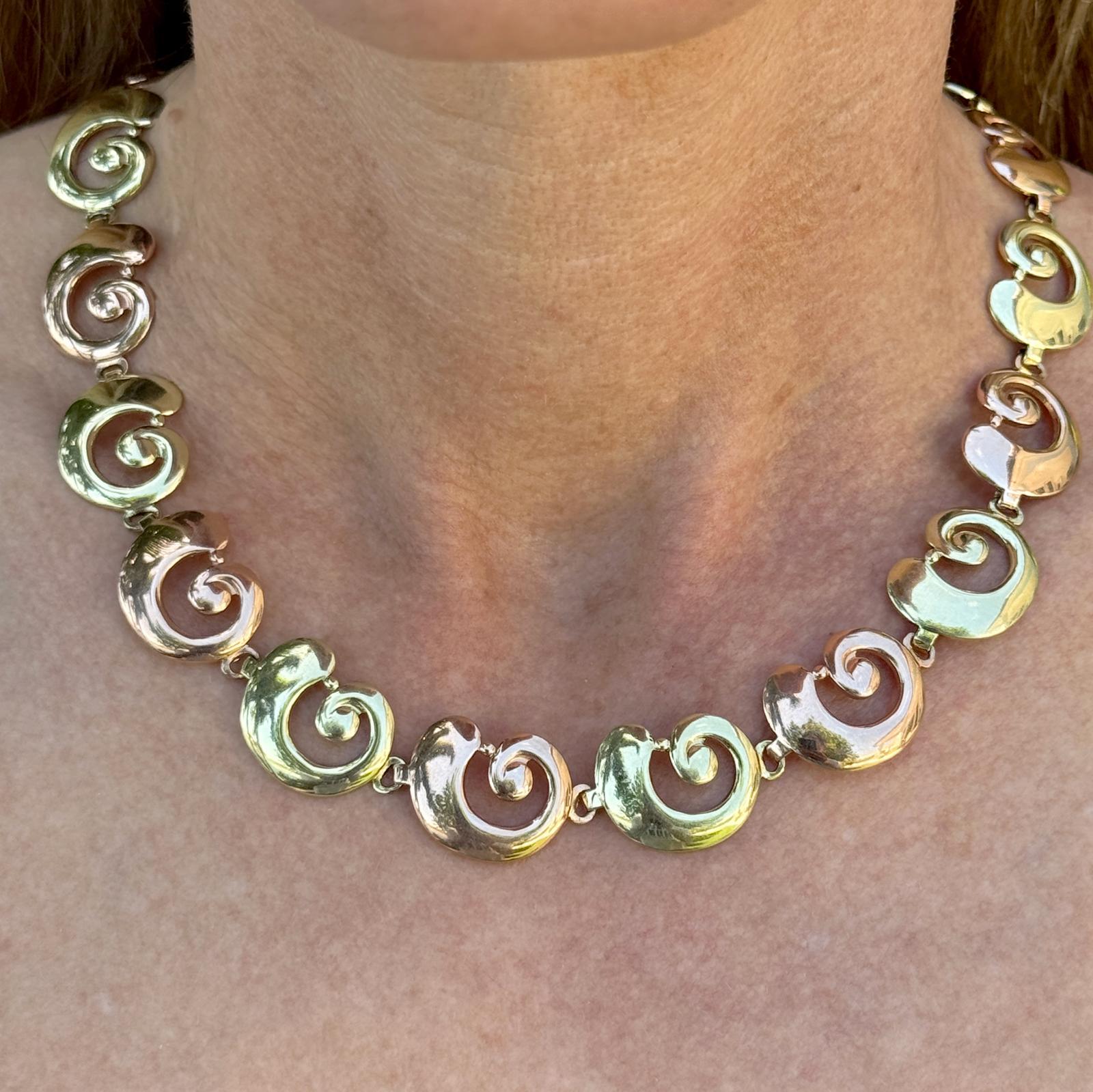 This mid-20th century Tiffany & Co. vintage necklace is a stunning example of timeless design and expert craftsmanship. Crafted in 14 karat yellow and rose gold and measuring 15.5 inches in length, the necklace features an elegant swirl motif that