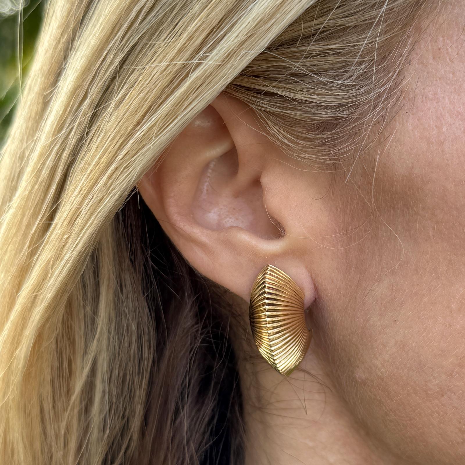 These elegant 14K yellow gold vintage Tiffany & Company Fluted ‘Shrimp’ Ribbed Earrings showcase the brand's signature craftsmanship and timeless design. Measuring 1.10 x 0.50 inches, the earclip earrings feature a distinctive ribbed, fluted texture