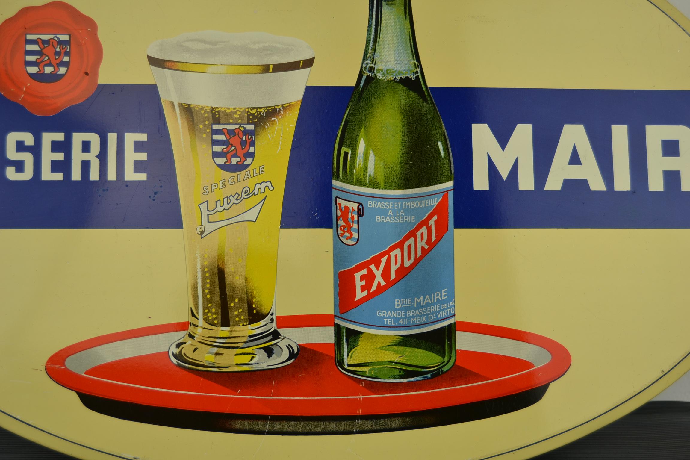 1950s Tin advertising sign for Belgian beer: 
Brasserie Maire - Speciale Luxem - Export Beer.
An advertising sign with a great design for blond beer:  a beer bottle and a beer glass on a porcelain serving tray. 

This oval sign is made by Rob Otten
