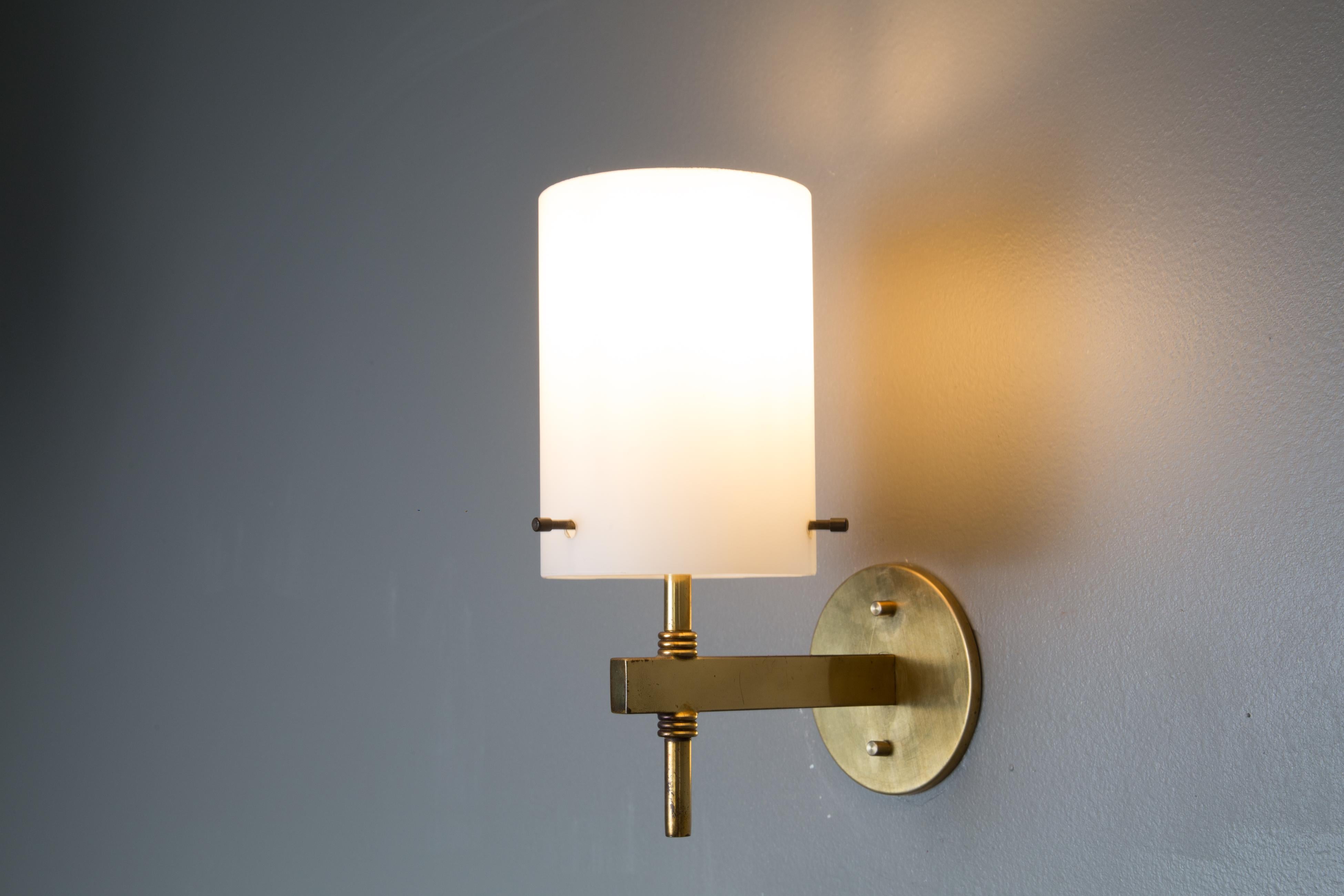 1950s Tito Agnoli brass & glass cylindrical wall lamp for O-Luce. Executed in opaline glass and patinated brass. An incredibly clean and refined design by one of the greatest Italian lighting icons of the modern age.

Price is per item. 4 lamps