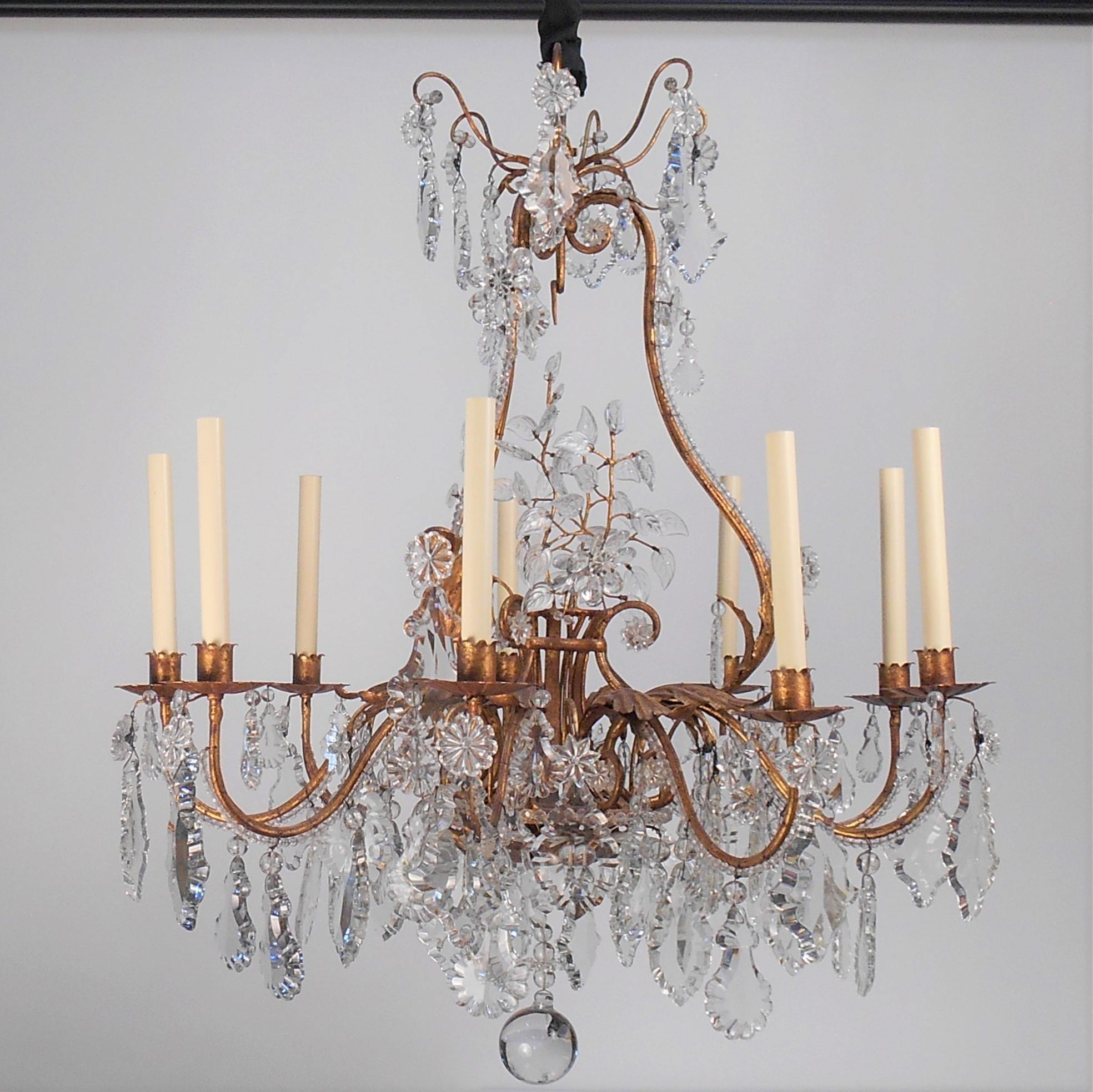 This iron, tole leaf and crystal chandelier feature intricately detailed crystal leaves, rosettes, beading and multiple shaped pendalogues. The tole finish is a rich heavily antiqued gold leaf with a patina equaling that of an 18th or 19th century