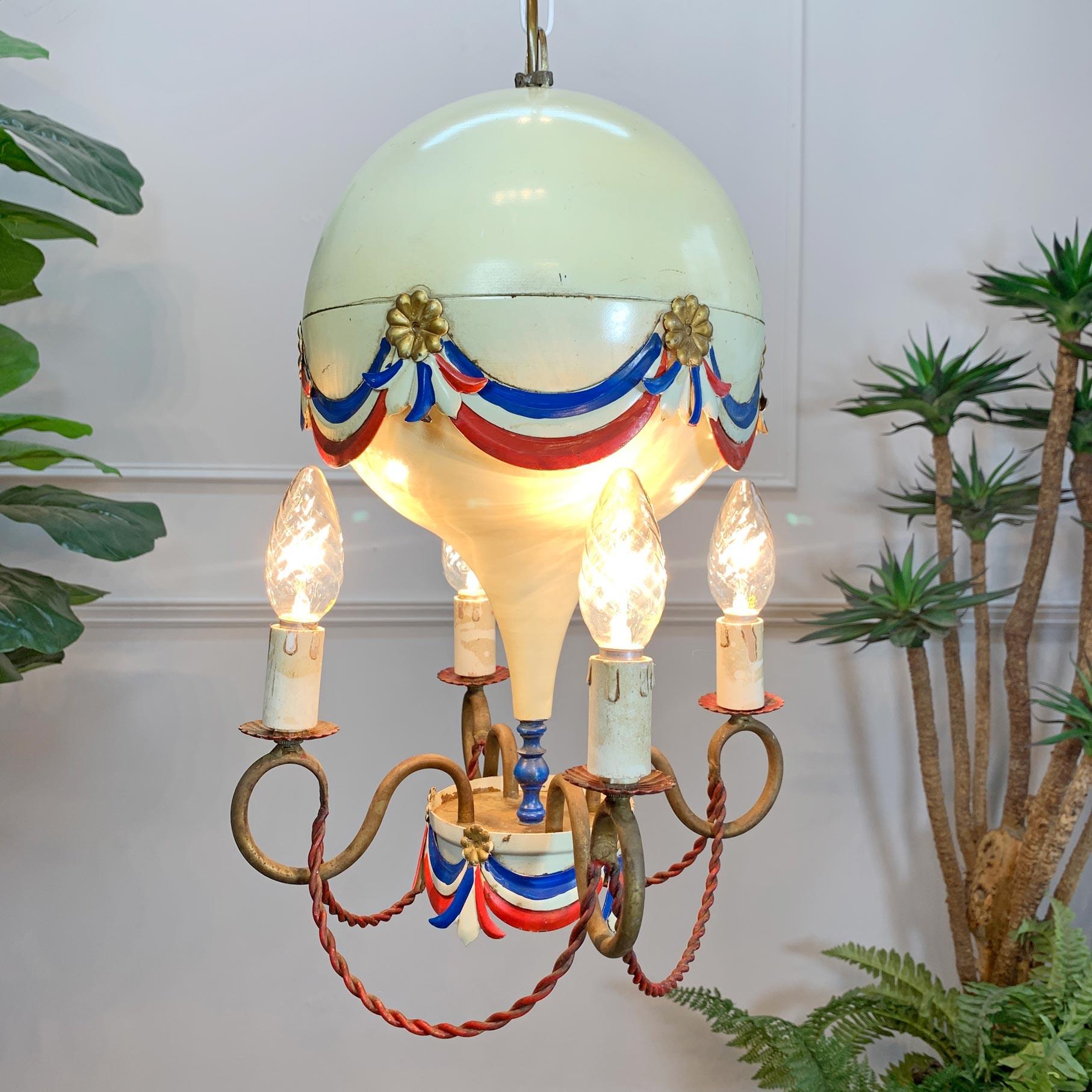 Mid century toleware hot air balloon chandelier, c 1950’s

This stunning light is a rare find in such great original condition
The main balloon body of the light is in full metal with original hand painted swags and rosettes in red,white, blue &