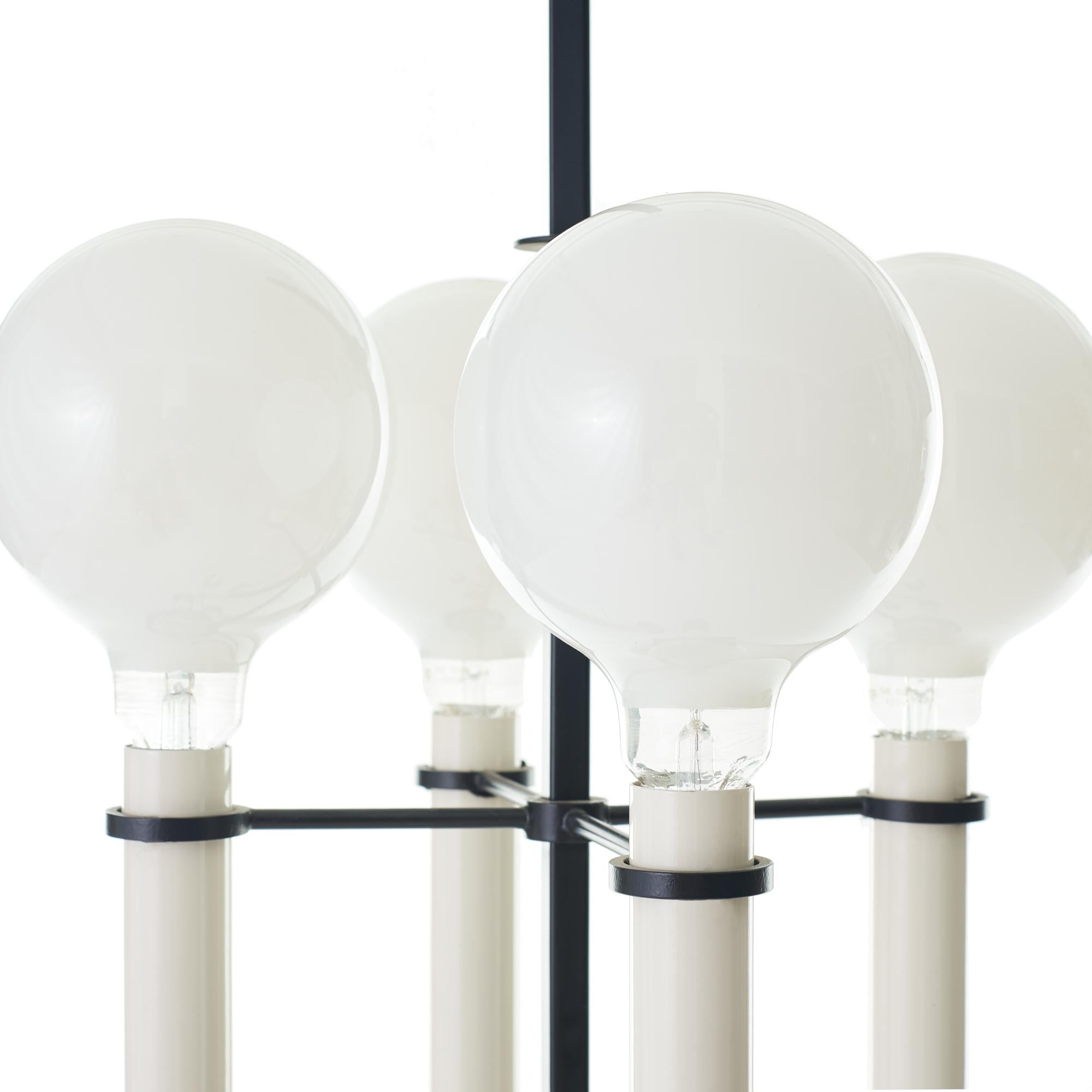 Elegant black steel floor lamp by Tommi Parzinger, circa 1950. Fitted with oversized globe bulbs, though originally this piece would have featured a lampshade. Switch located at base, recently rewired with period-appropriate wrapped